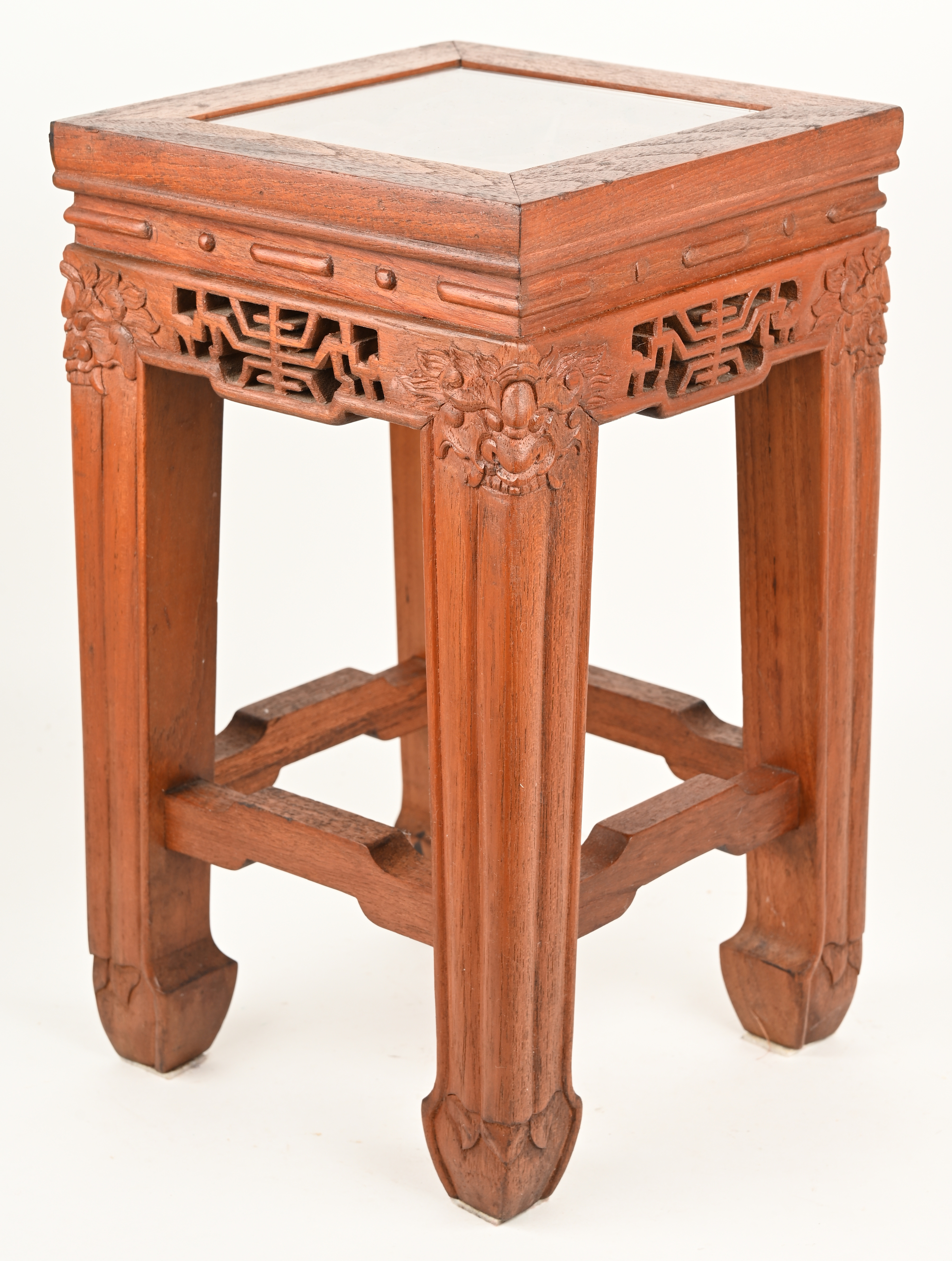 Een klein Chinees houten sokkeltje met gesculpteerd decor in het blad onder glas en drakenkoppen op de hoeken Een klein Chinees houten sokkeltje met gesculpteerd decor in het blad onder glas en drakenkoppen op de hoeken.