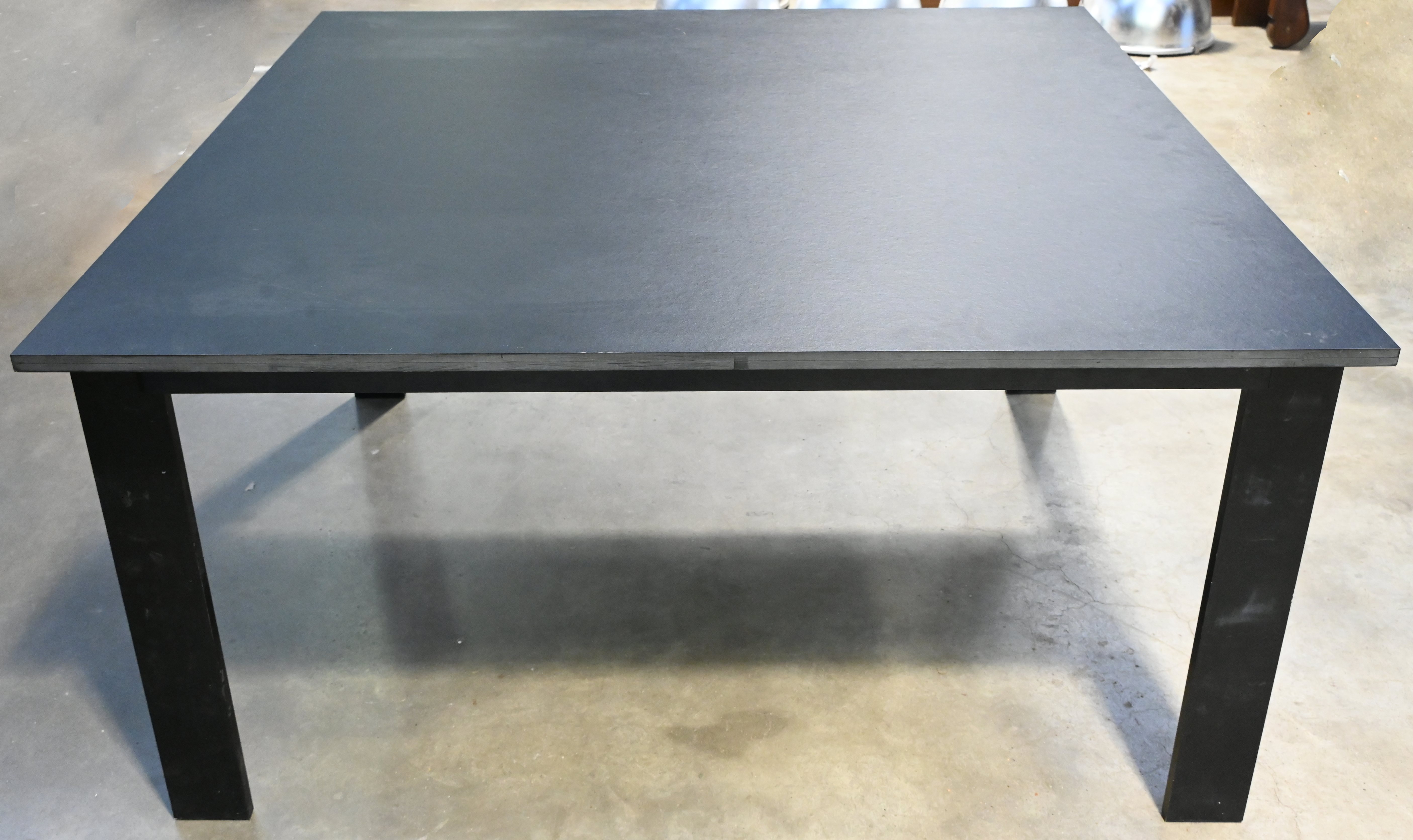 Een modernistische tafel in zwart gelakt staal en hout Een modernistische tafel in zwart gelakt staal en hout.