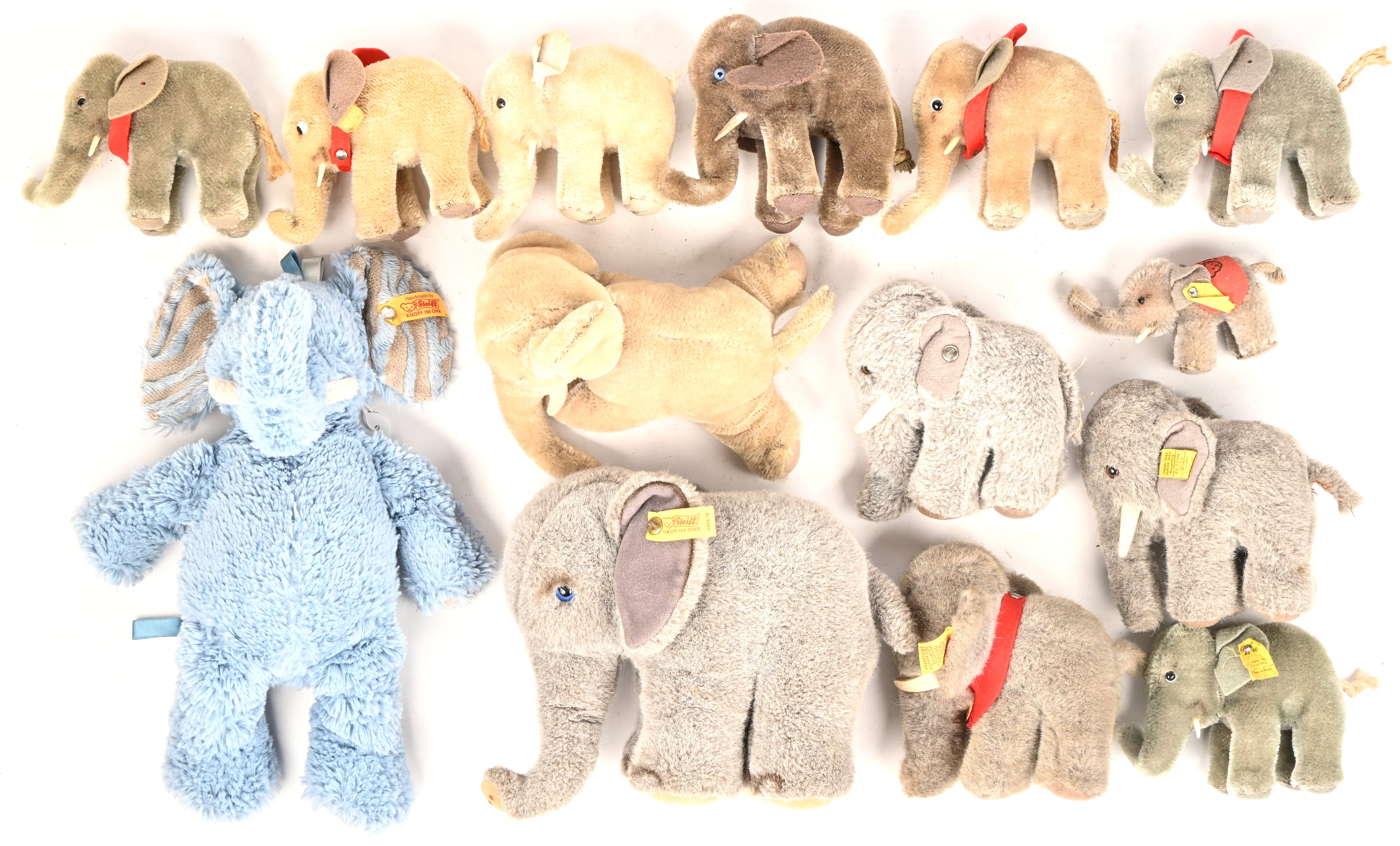 Veertien pluche olifanten waarvan negen gemerkt Steiff, de overige vijf met de knop manco Veertien pluche olifanten waarvan negen gemerkt Steiff, de overige vijf met de knop manco.