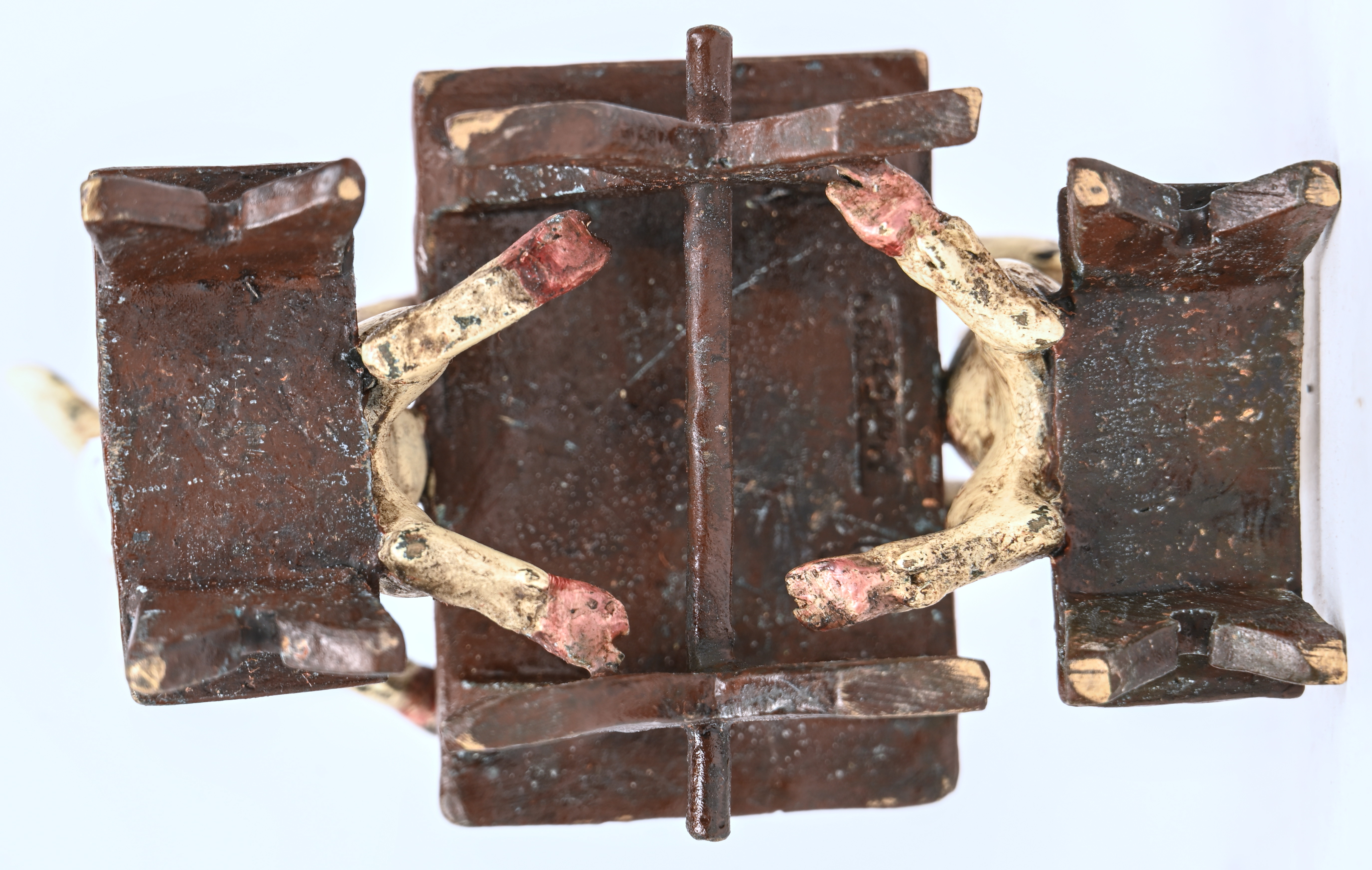 Twee polychrome bronzen varkentjes aan de feestdis Twee polychrome bronzen varkentjes aan de feestdis.