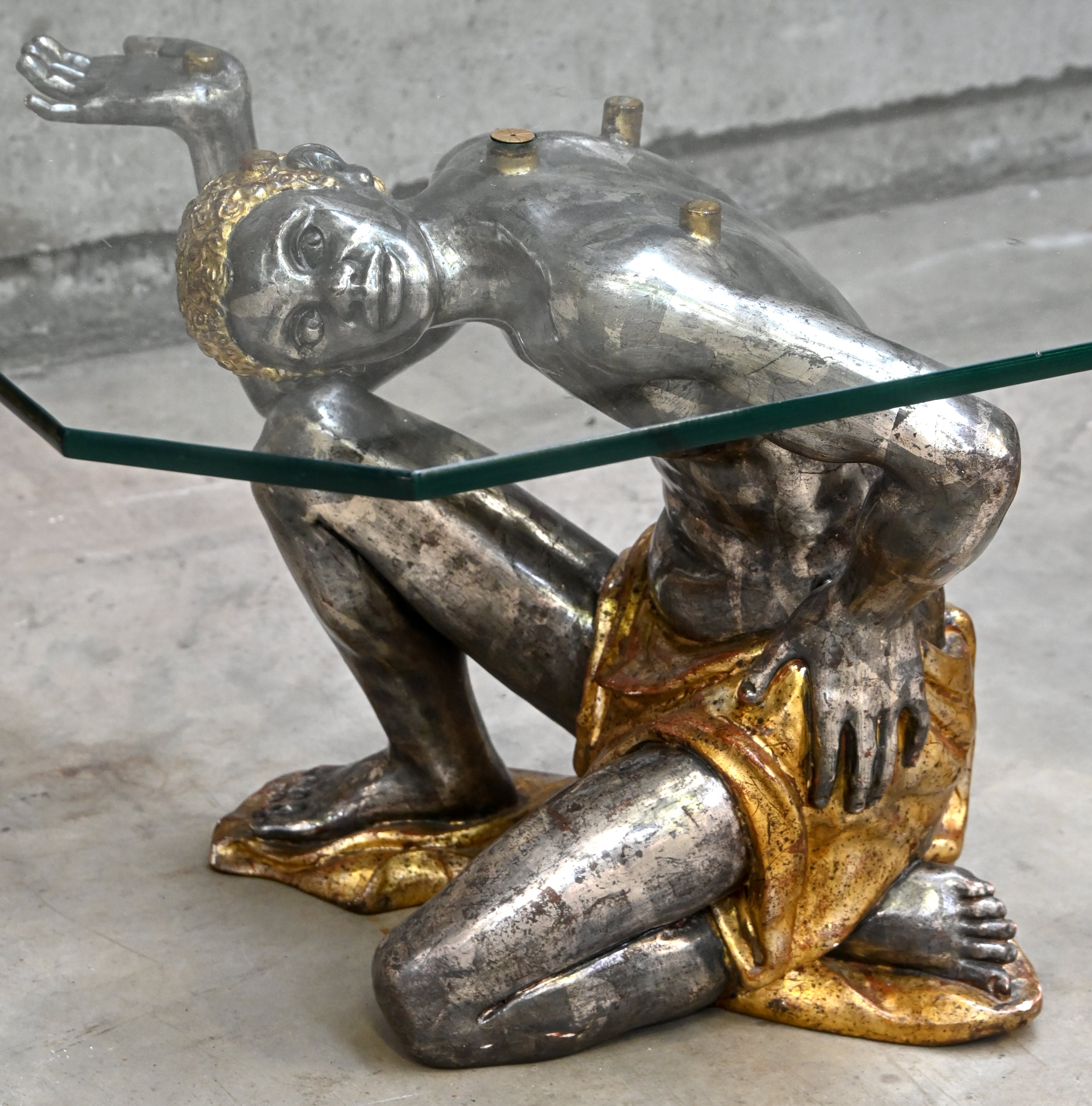 Een salontafel met glazen blad rustend op twee Moorse figuren in kunststof, vermoedelijk Italiaans, circa 1980/90 Een salontafel met glazen blad rustend op twee Moorse figuren in kunststof, vermoedelijk Italiaans, circa 1980/90.