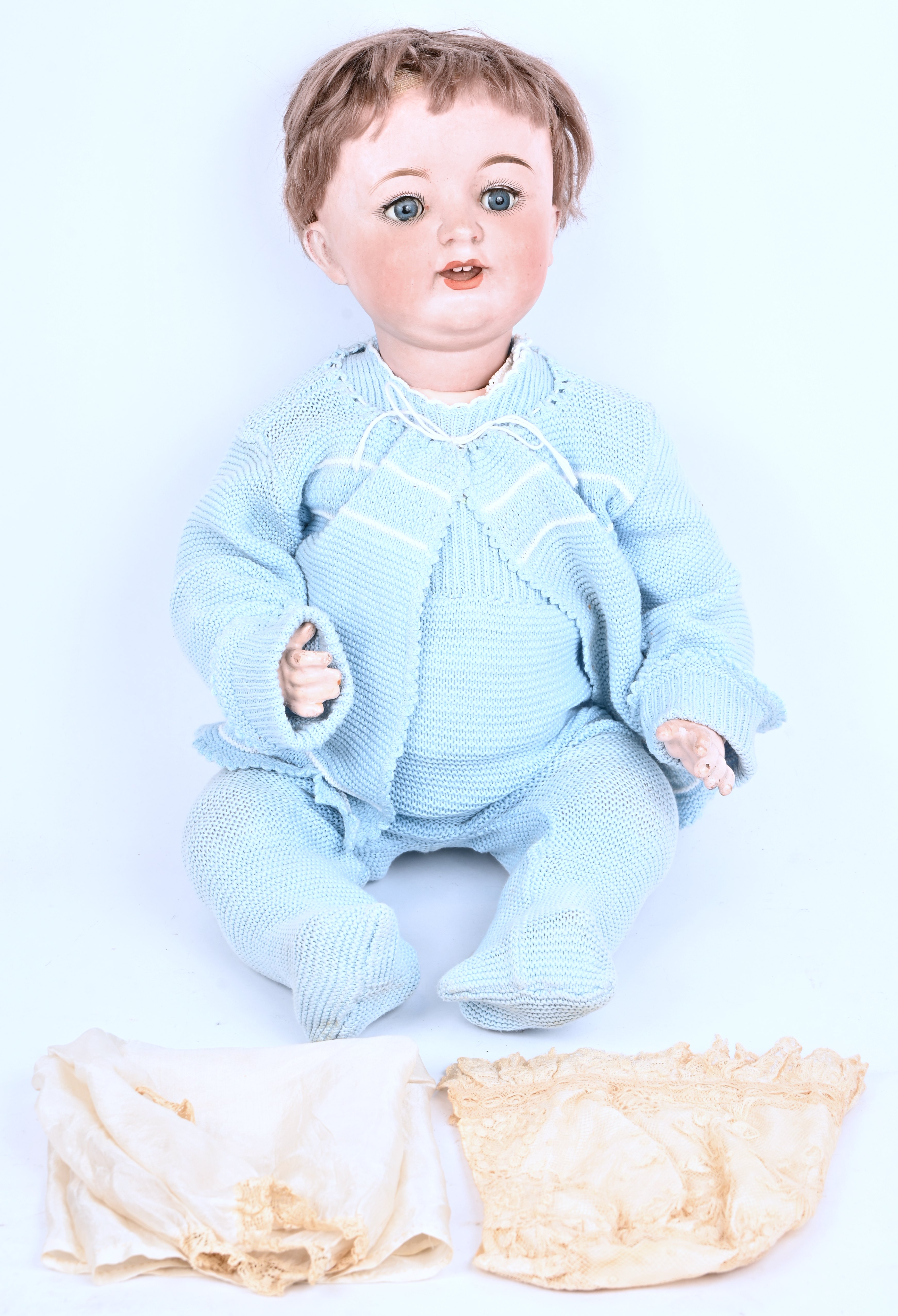 Een antieke pop met porseleinen hoofd. Met open mond en slaapogen. Gemerkt op het hoofd 6789/40, Germany. Toegevoegd slaapkleedje en muts van zijde met kant Een antieke pop met porseleinen hoofd. Met open mond en slaapogen. Gemerkt op het hoofd 6789/40, Germany. Toegevoegd slaapkleedje en muts van zijde met kant.