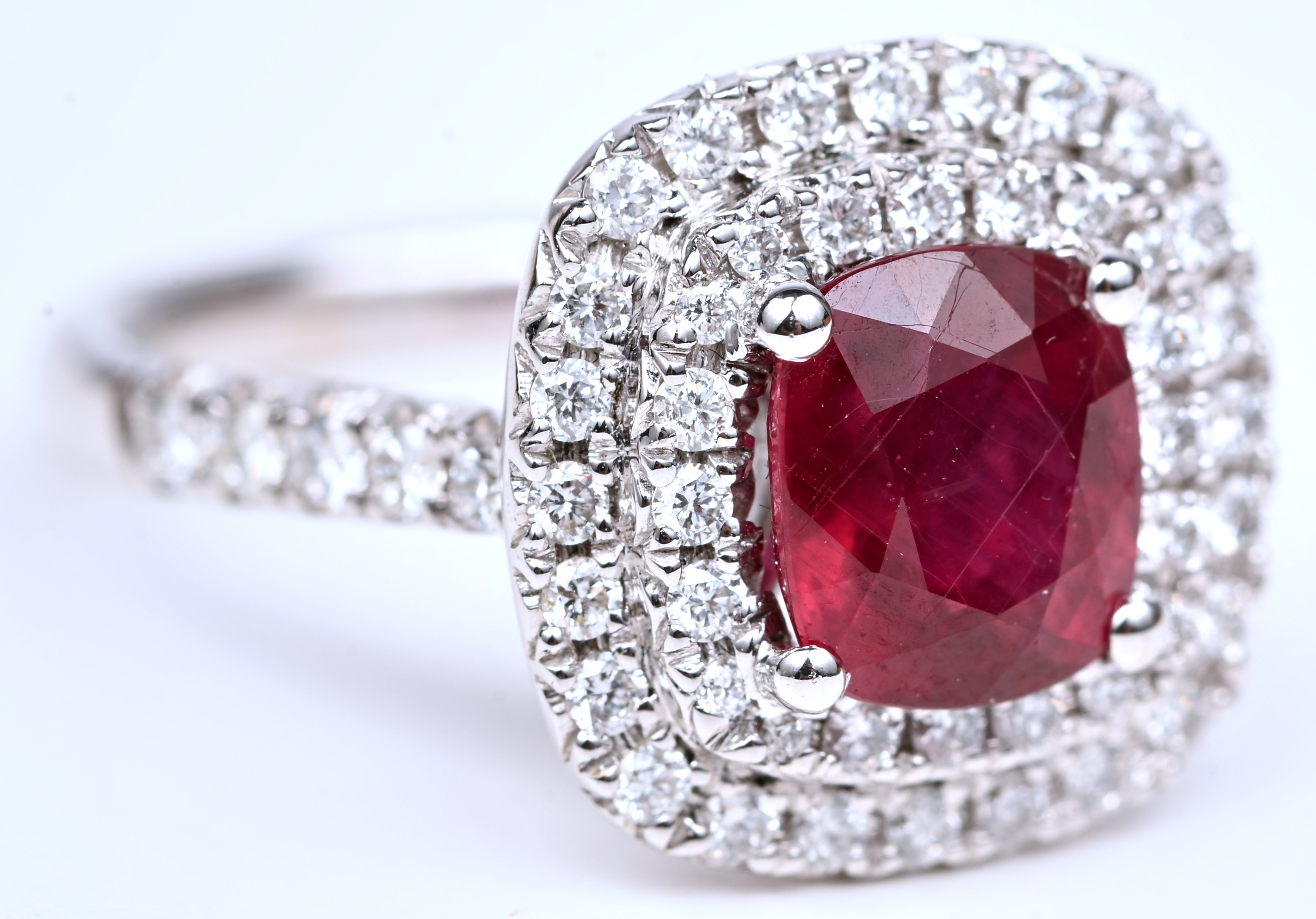 Een 18 kt witgouden ring bezet met briljanten met een gezamenlik gewicht van +- 0,72 ct. en een centrale robijn van +- 3 ct Een 18 kt witgouden ring bezet met briljanten met een gezamenlik gewicht van +- 0,72 ct. en een centrale robijn van +- 3 ct.