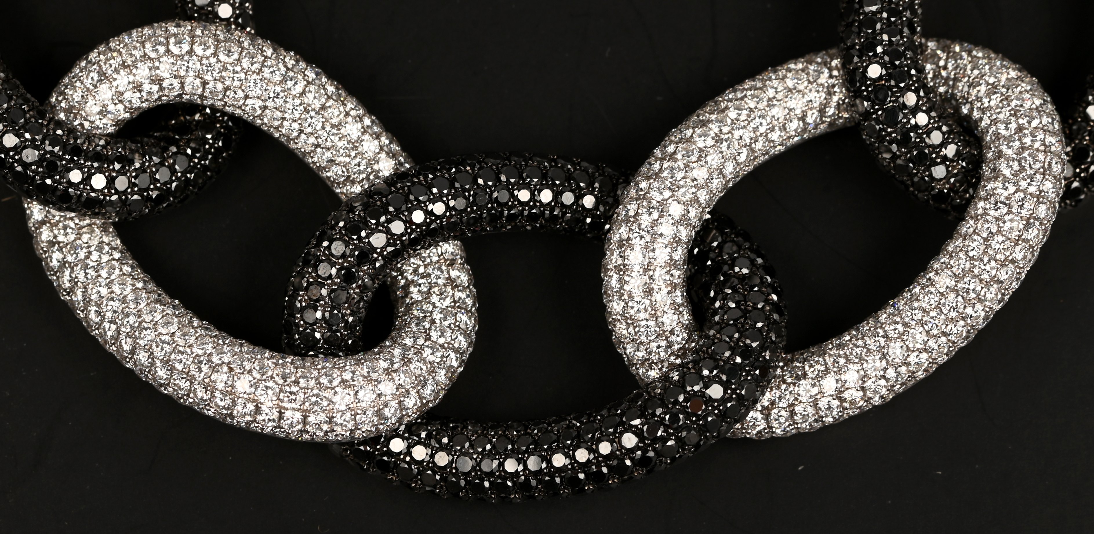 Een 18 karaats witgouden schakelarmband bezet met briljanten met een gezamenlijk gewicht van +- 18,01 ct. en zwarte diamanten met een gezamenlijk gewicht van +- 20,32 ct. Met certificaat Een 18 karaats witgouden schakelarmband bezet met briljanten met een gezamenlijk gewicht van +- 18,01 ct. en zwarte diamanten met een gezamenlijk gewicht van +- 20,32 ct. Met certificaat.