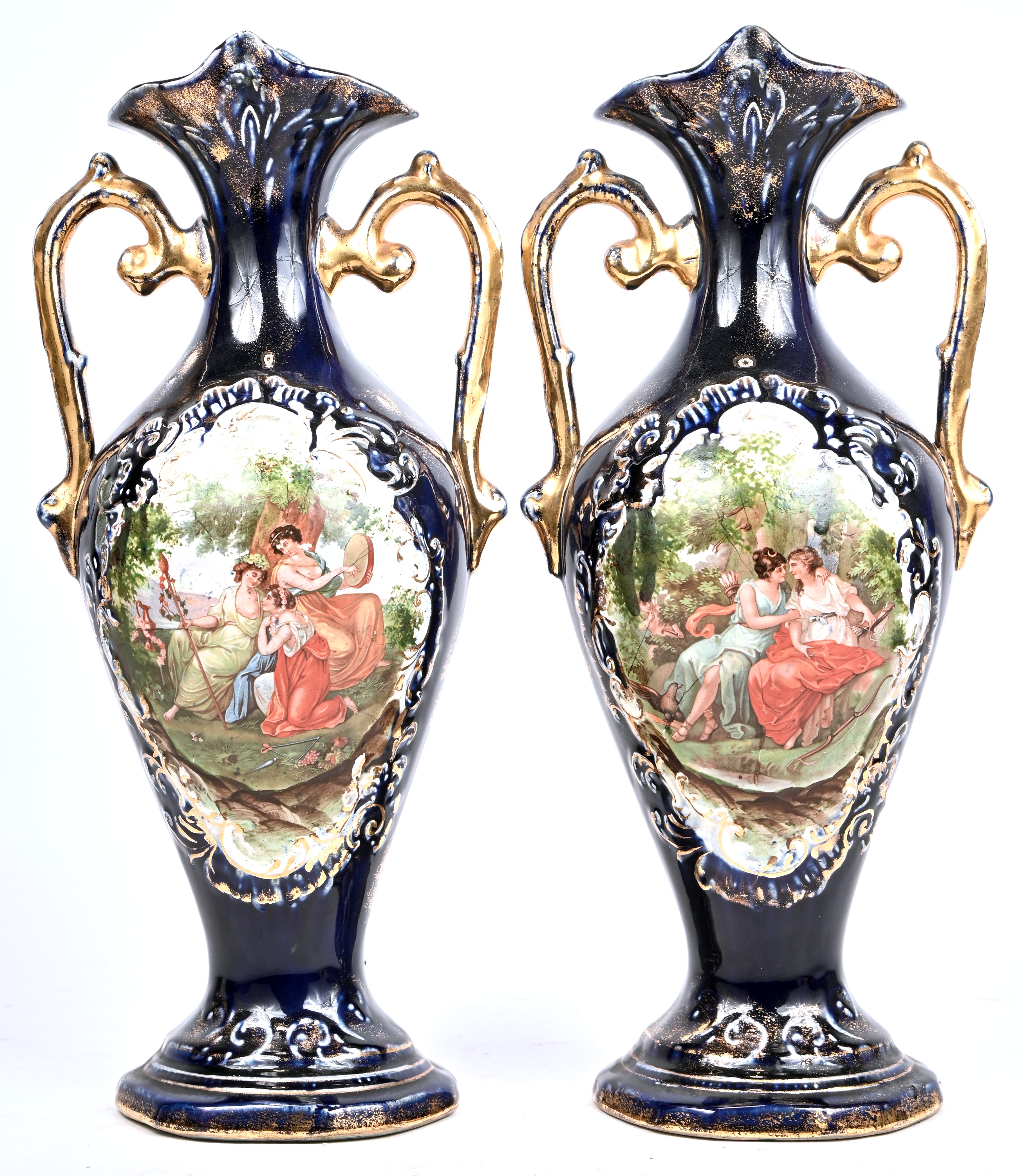 Een paar kobaltblauwe aardewerken vazen, versierd met romantische scènes in uitsparingen. Met twee vergulde oren Een paar kobaltblauwe aardewerken vazen, versierd met romantische scènes in uitsparingen. Met twee vergulde oren.