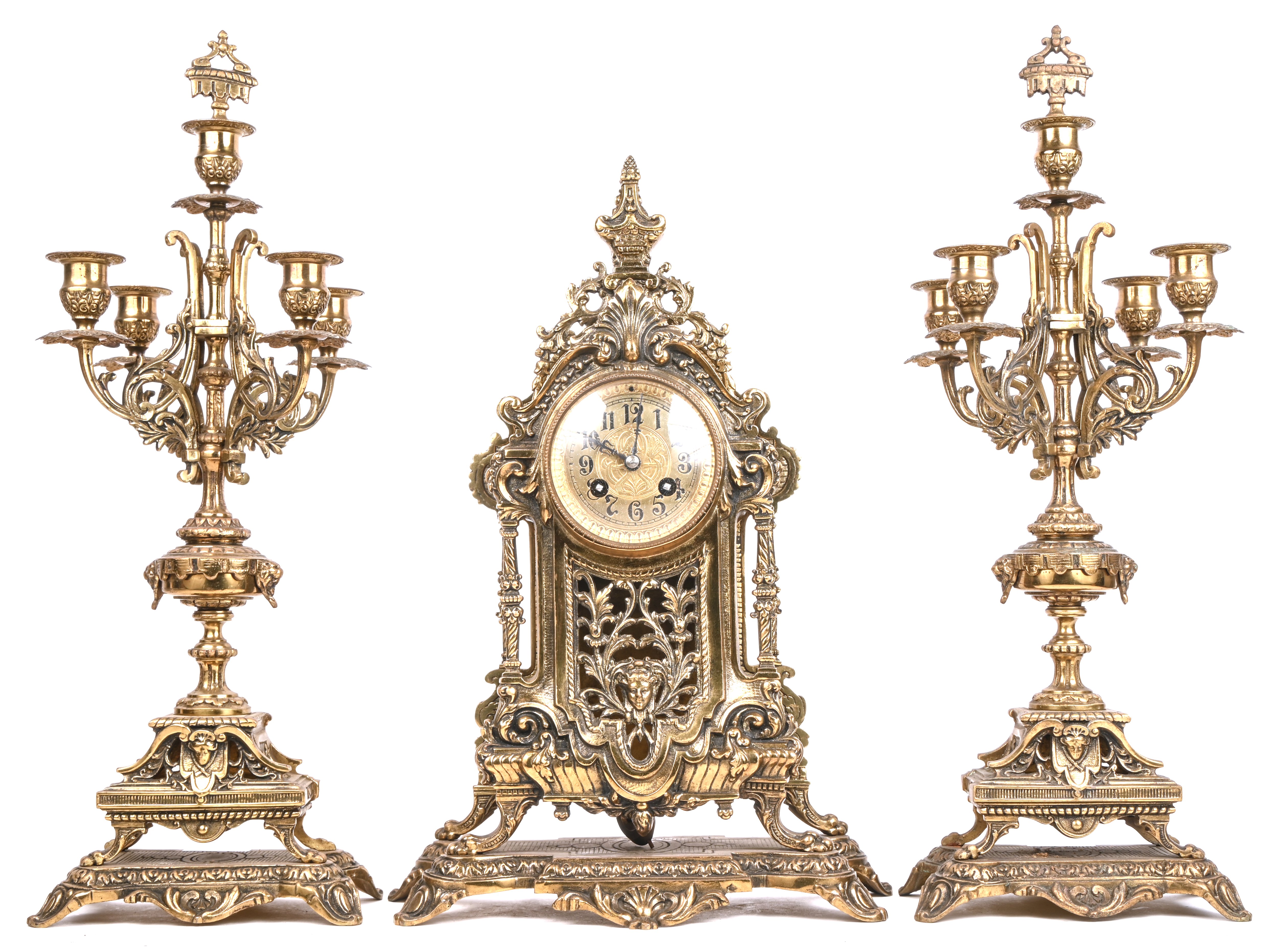 Een bronzen mantelklok in barokke stijl, met een paar bijpassende kandelaars Een bronzen mantelklok in barokke stijl, met een paar bijpassende kandelaars.
