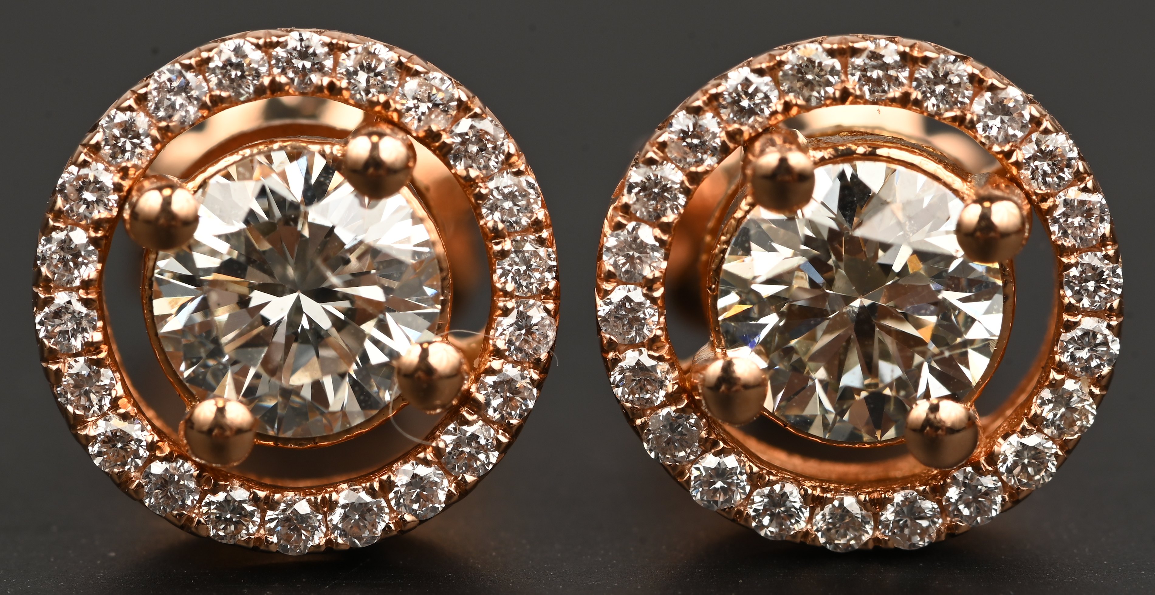 Een paar 18 karaats roosgouden oorbellen met twee briljanten met een gezamenlijk gewicht van +- 1,08 ct. HVS en briljanten met een gezamenlijk gewicht van +- 0,28 ct. FVVS Een paar 18 karaats roosgouden oorbellen met twee briljanten met een gezamenlijk gewicht van +- 1,08 ct. HVS en briljanten met een gezamenlijk gewicht van +- 0,28 ct. FVVS.