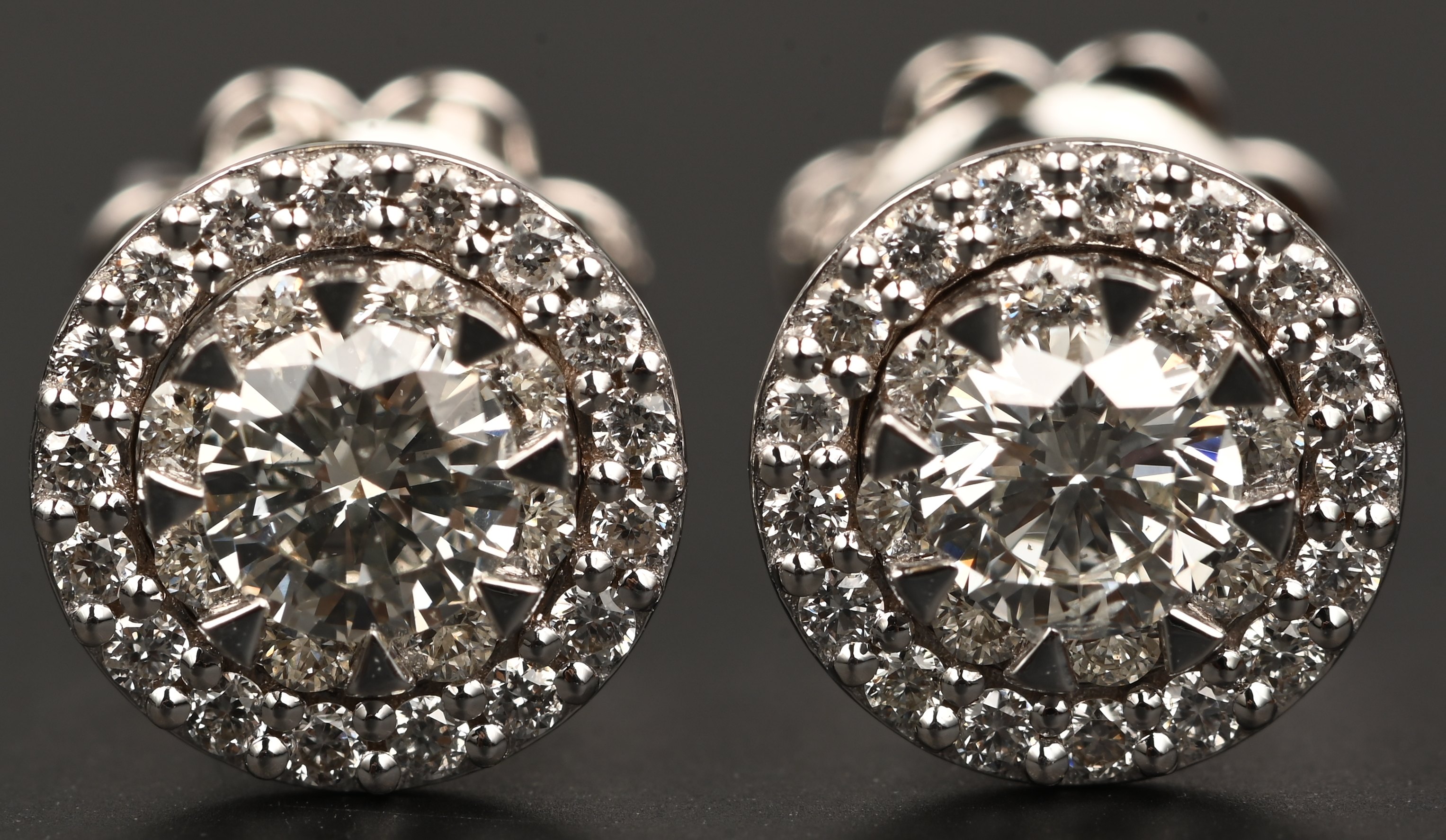 Een paar 18 karaats witgouden oorbellen bezet met twee centrale briljanten met een gezamenlijk gewicht van +- 0,40 ct . FVS2 en briljanten met een gezamenlijk gewicht van 0,30 ct. FVS1 Een paar 18 karaats witgouden oorbellen bezet met twee centrale briljanten met een gezamenlijk gewicht van +- 0,40 ct . FVS2 en briljanten met een gezamenlijk gewicht van 0,30 ct. FVS1.