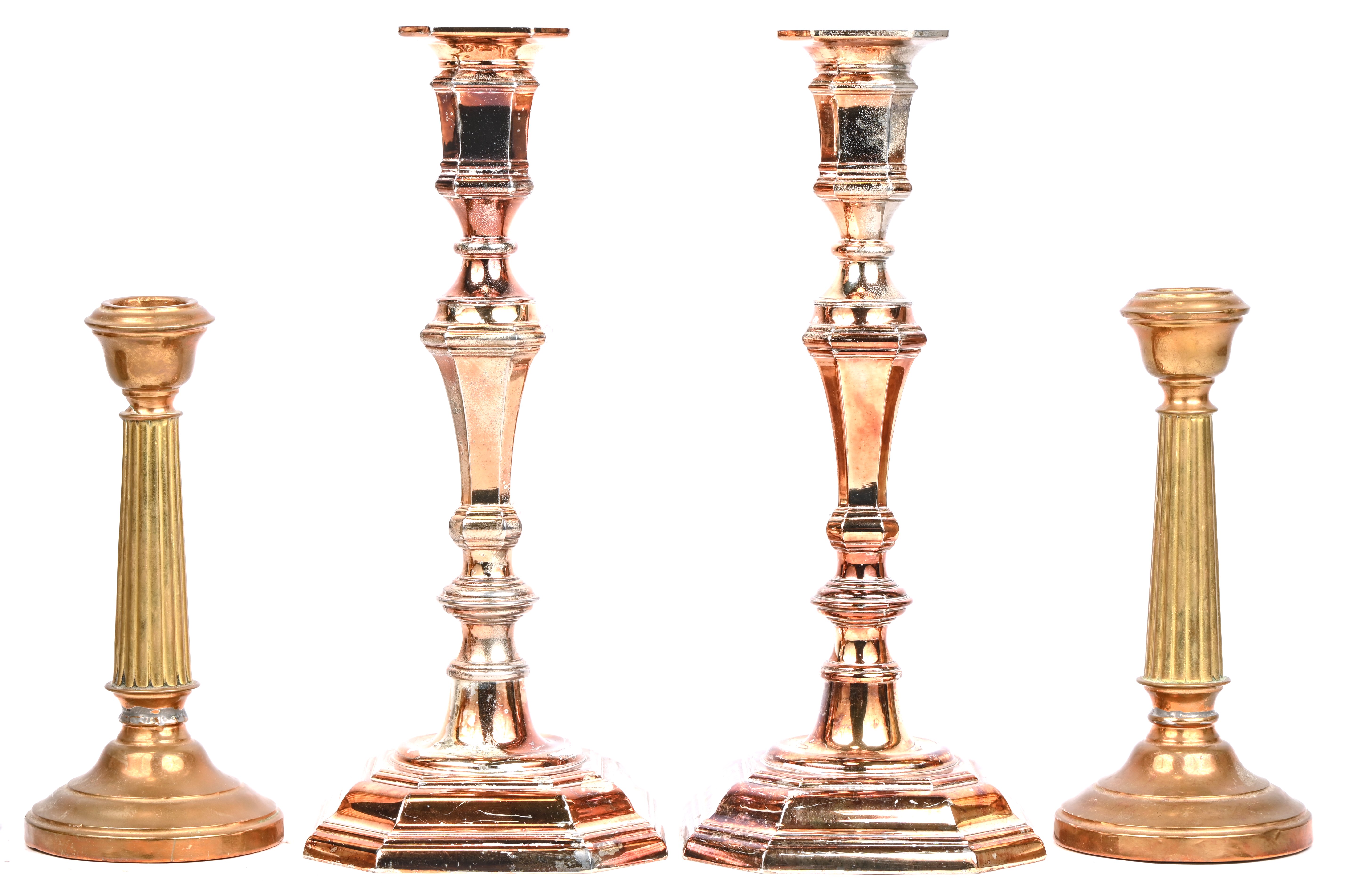 Twee paar kandelaars, een set van zilverkleurig metaal en een set van rood en geel koper Twee paar kandelaars, een set van zilverkleurig metaal en een set van rood en geel koper.