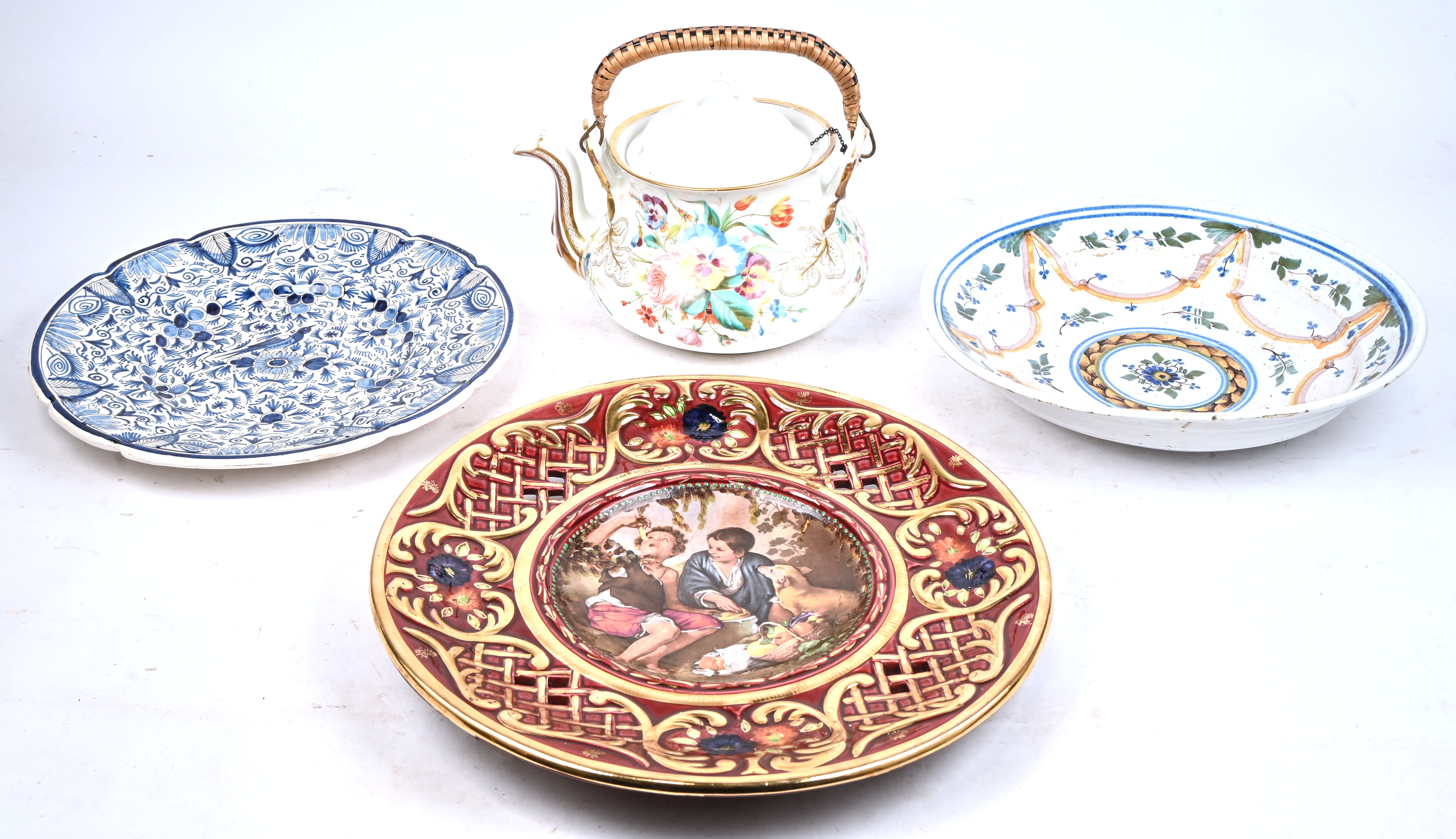 Drie aardewerken schotels in verschillende stijlen en een grote koffiepot van meerkleurig porselein Drie aardewerken schotels in verschillende stijlen en een grote koffiepot van meerkleurig porselein.