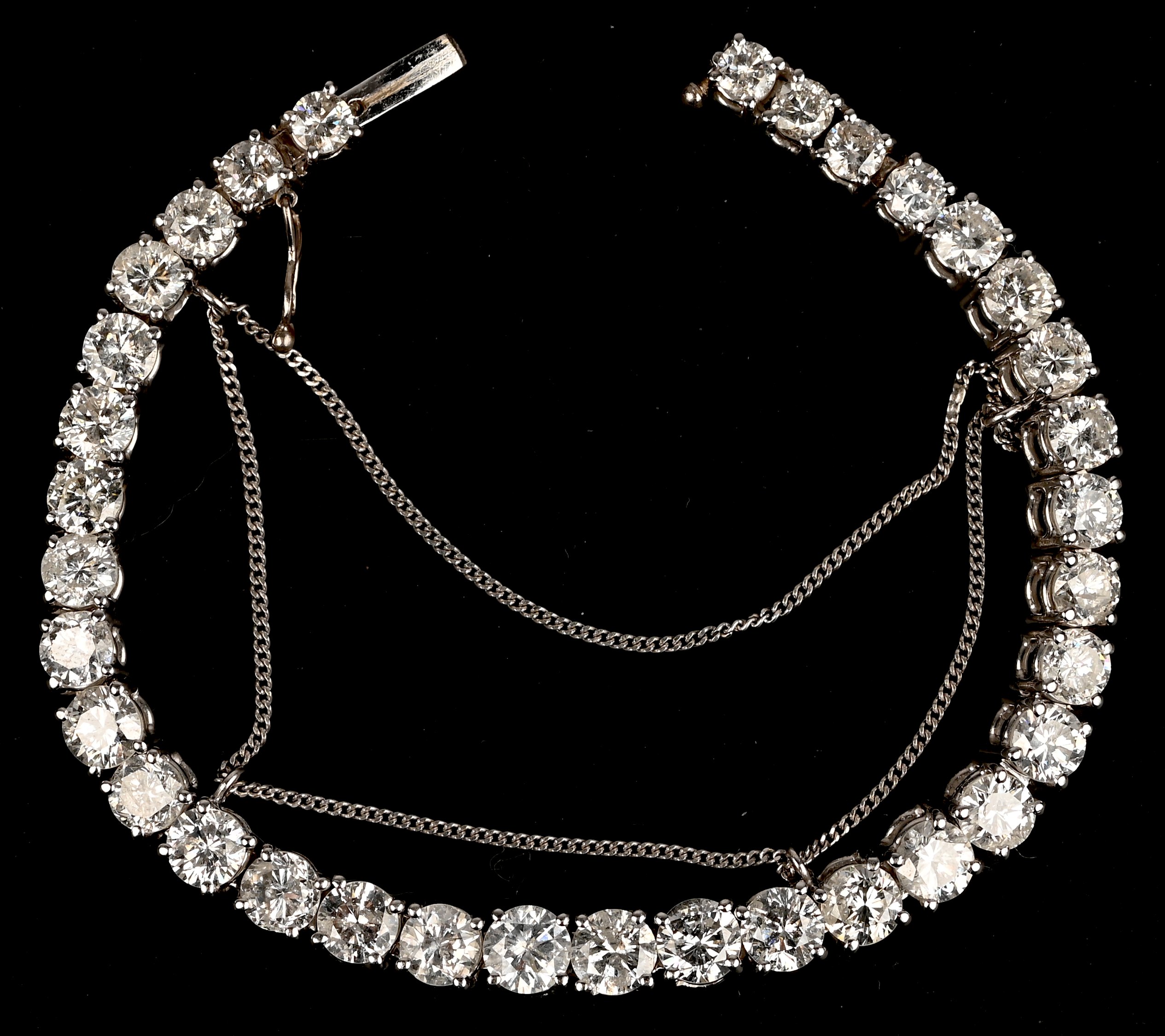 Een 18 karaats witgouden riviére armband bezet met 34 briljanten met een gezamenlijk gewicht van +- 17,80 ct. GH P1 P2 Een 18 karaats witgouden riviére armband bezet met 34 briljanten met een gezamenlijk gewicht van +- 17,80 ct. GH P1 P2.