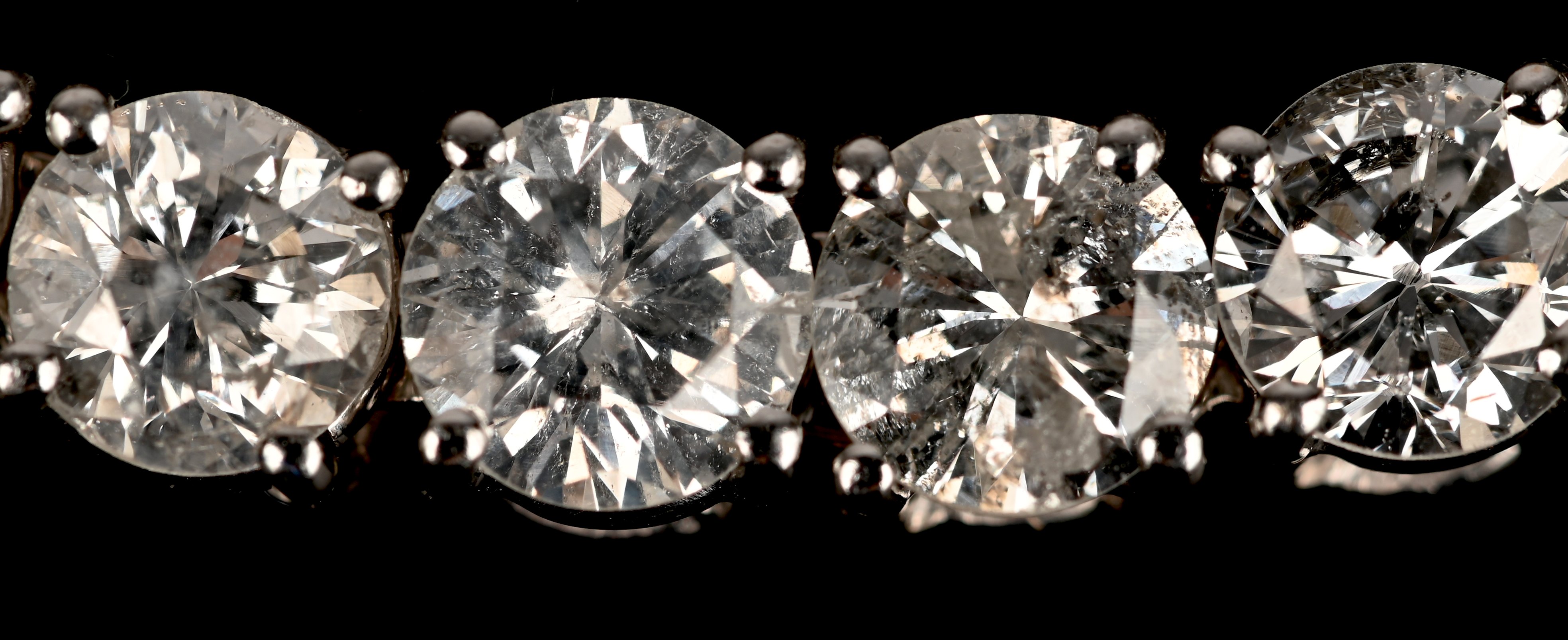 Een 18 karaats witgouden riviére armband bezet met 34 briljanten met een gezamenlijk gewicht van +- 17,80 ct. GH P1 P2 Een 18 karaats witgouden riviére armband bezet met 34 briljanten met een gezamenlijk gewicht van +- 17,80 ct. GH P1 P2.