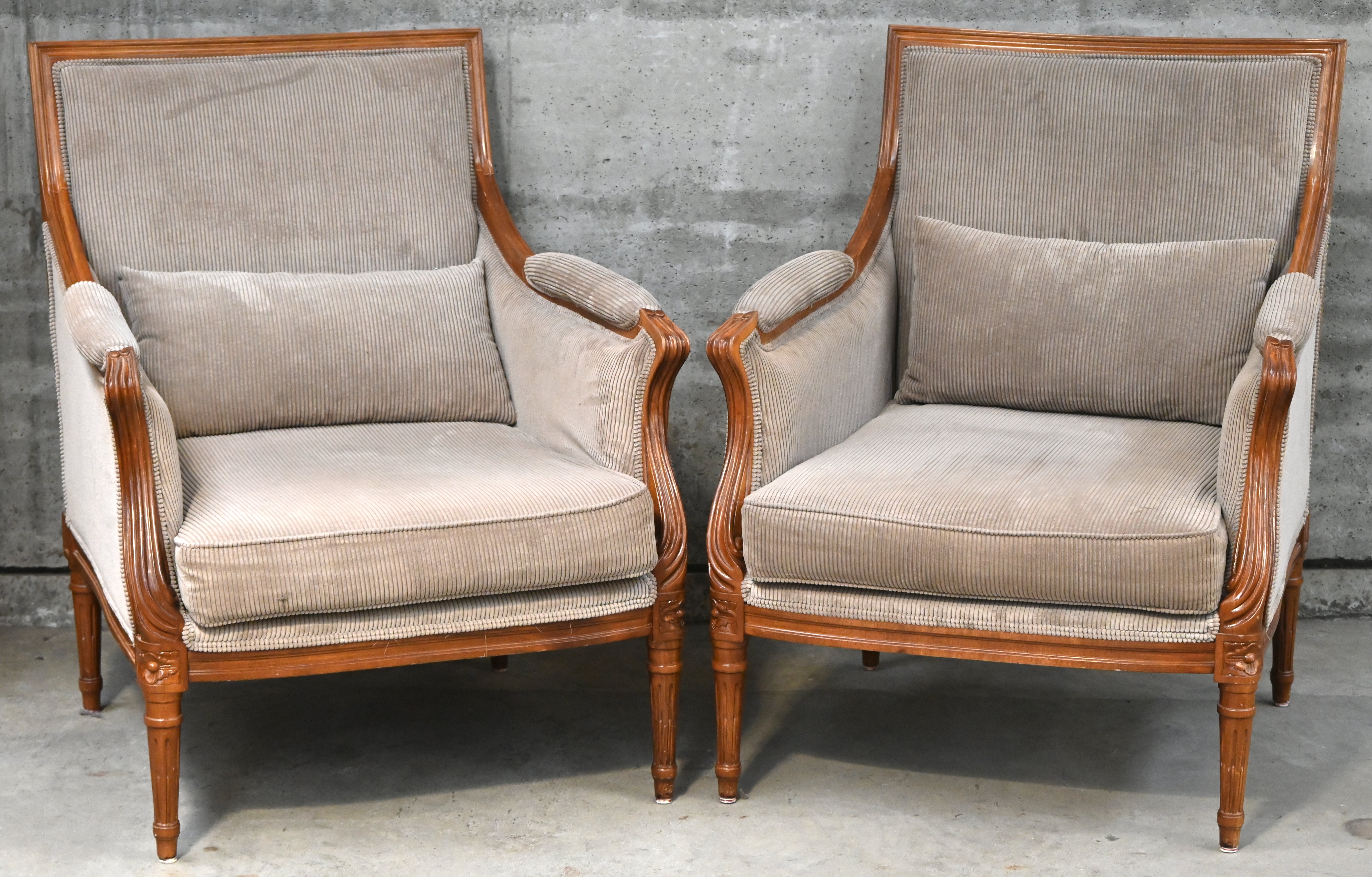 Een set van twee klassieke fauteauils, houten frame en lichtbruine velours bekleding Een set van twee klassieke fauteauils, houten frame en lichtbruine velours bekleding.