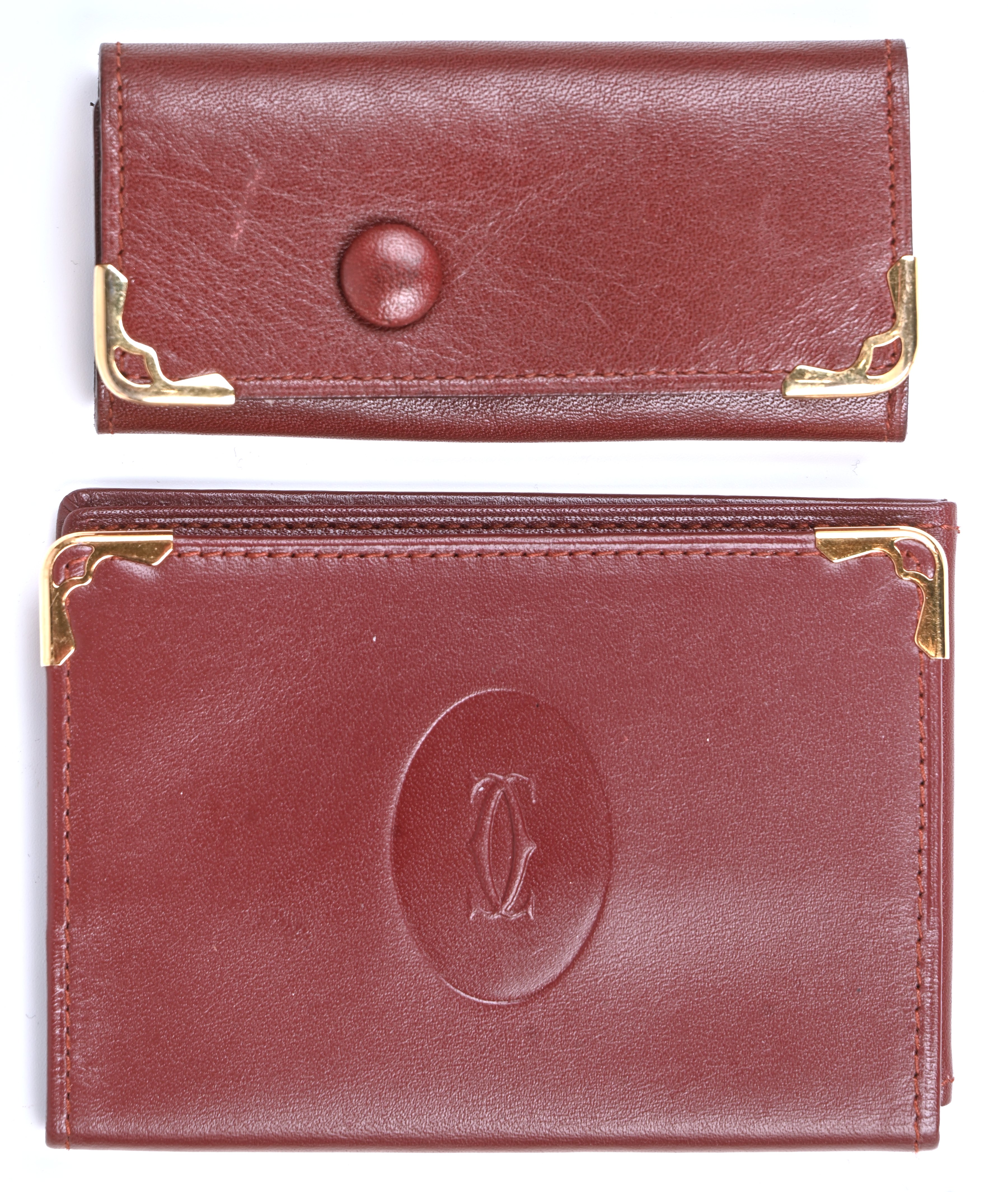 Een bruin lederen sleutelhanger en kaarthouder met vergulde elementen. Gemerkt Een bruin lederen sleutelhanger en kaarthouder met vergulde elementen. Gemerkt.