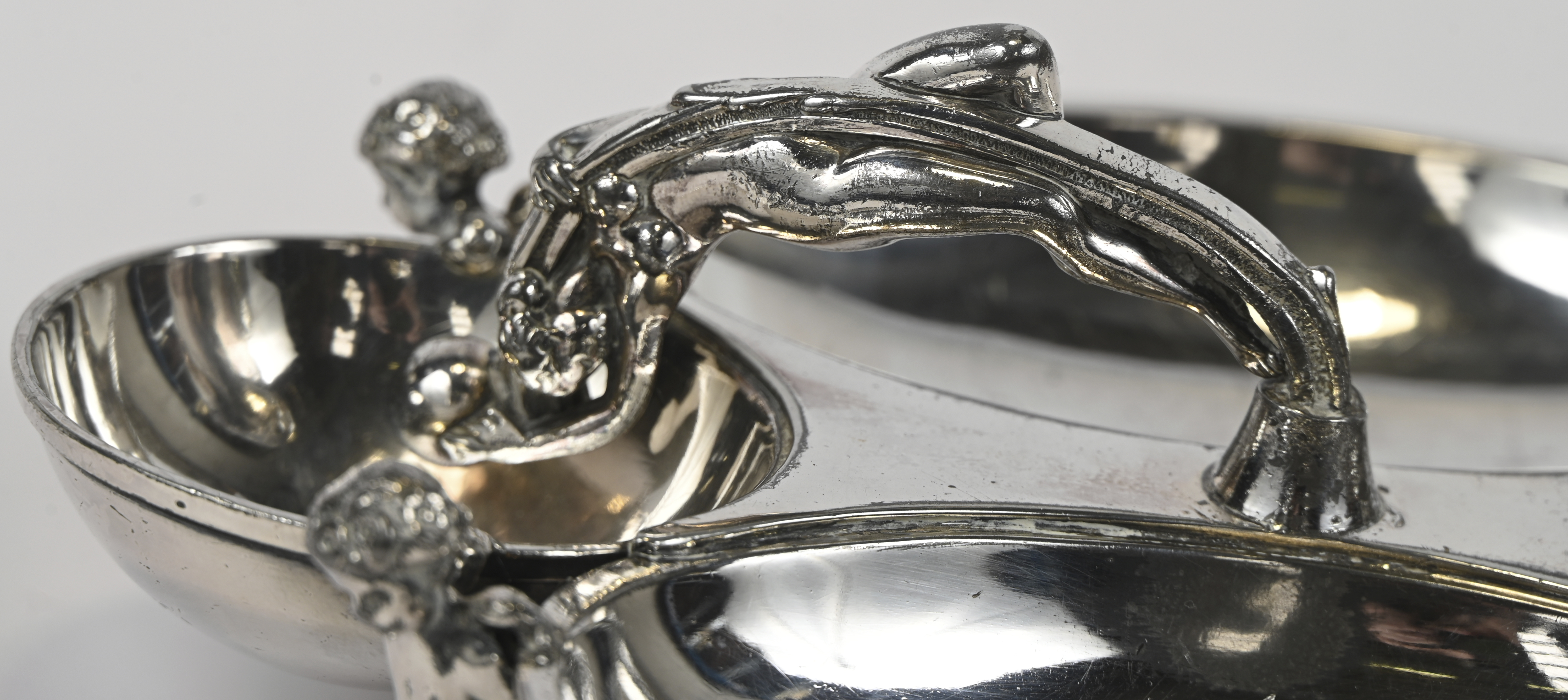 Een hors d’oeuvreschaaltje met drie coupes, gedragen door putti en handvat in de vorm van een naakt. Eén putto opnieuw te solderen Een hors d’oeuvreschaaltje met drie coupes, gedragen door putti en handvat in de vorm van een naakt. Eén putto opnieuw te solderen. AR19