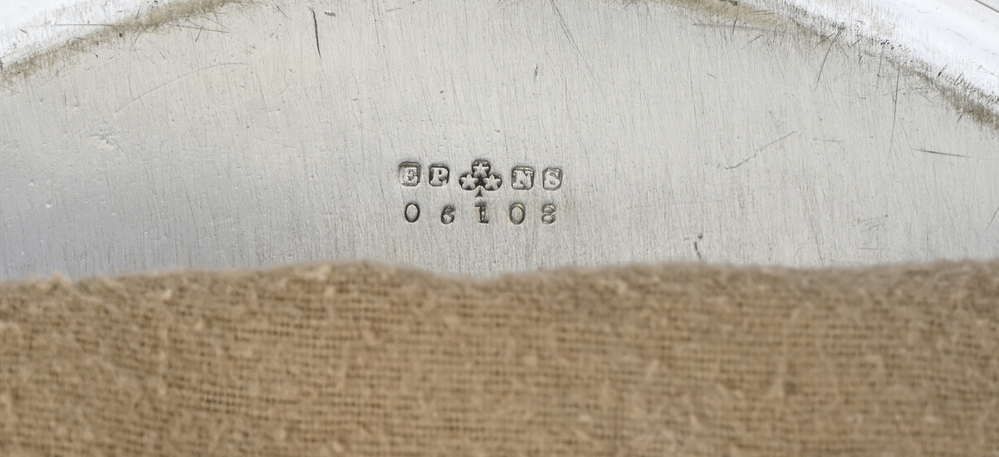 Een ronde schotel met een gedreven druivenrand. Gemerkt E.P.en genummerd Een ronde schotel met een gedreven druivenrand. Gemerkt E.P.en genummerd.