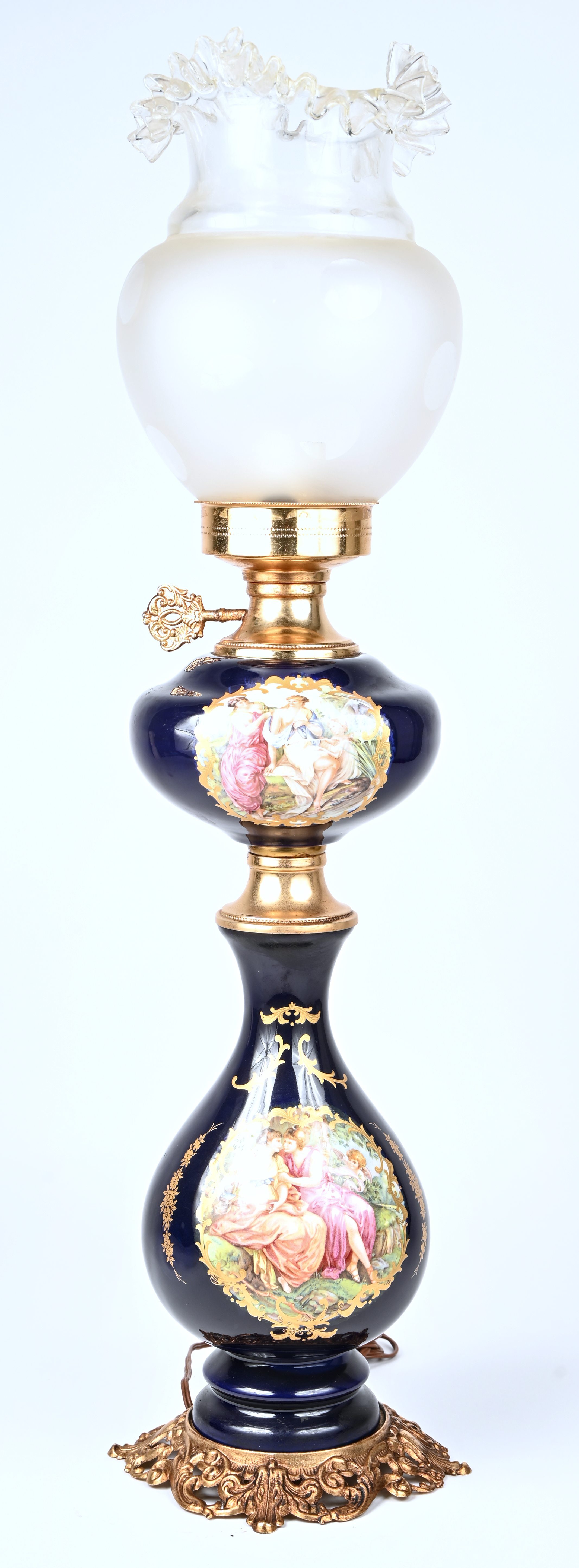 Een olielamp van kobaltblauw porselein, messing en glas Een olielamp van kobaltblauw porselein, messing en glas.