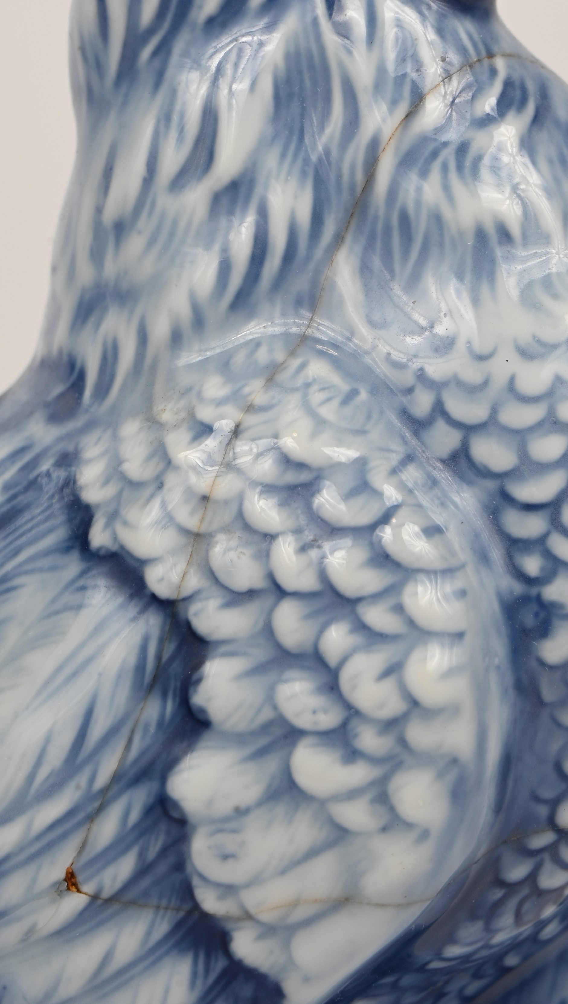 Een lot van 5 porseleinen beeldjes, een koolmeesje op stronk, 2 blauw-witte hanen waarvan 1 gelijmd en een peper- en zoutvaatje in de vorm van een kip en een haan Een lot van 5 porseleinen beeldjes, een koolmeesje op stronk, 2 blauw-witte hanen waarvan 1 gelijmd en een peper- en zoutvaatje in de vorm van een kip en een haan.