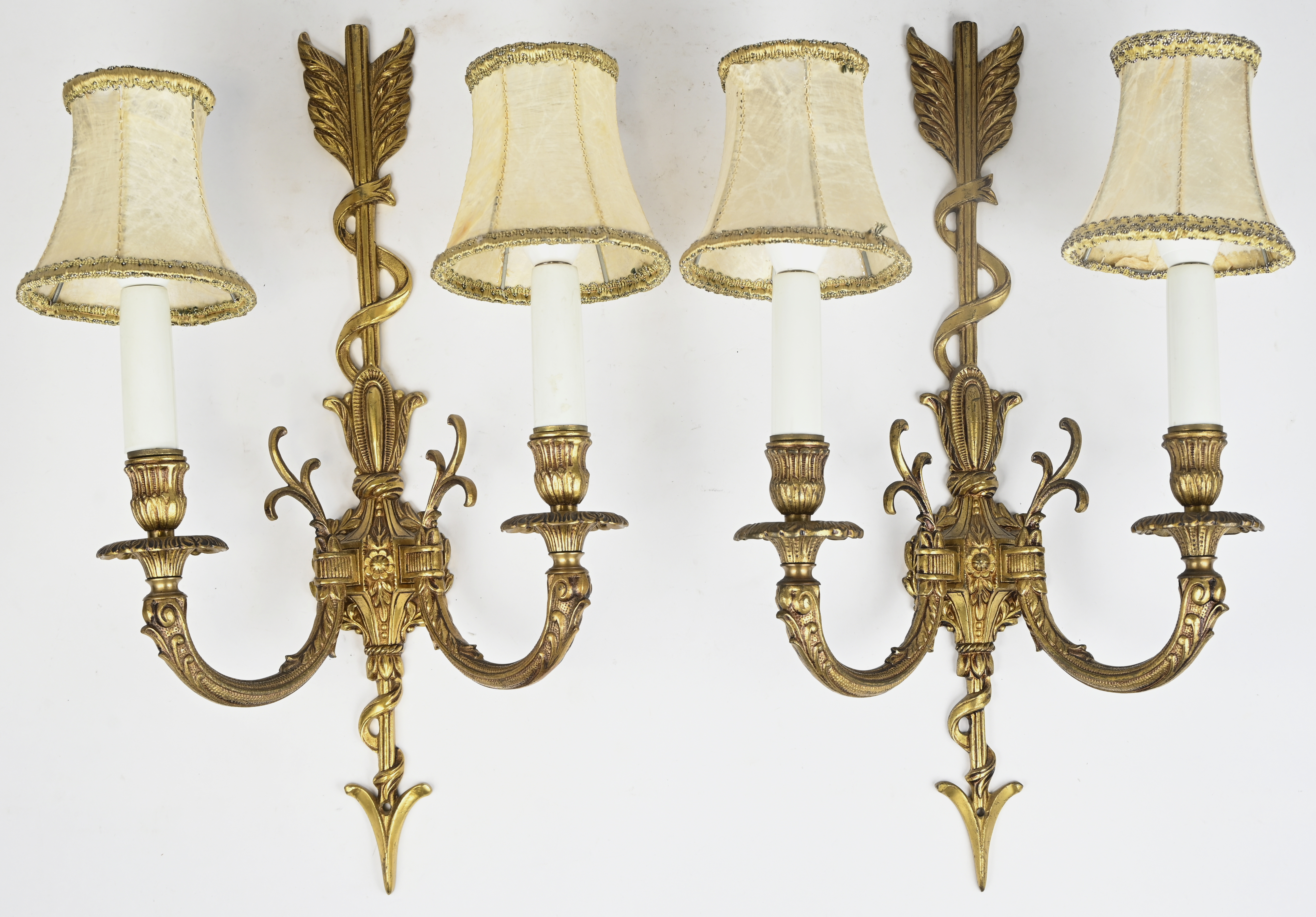 Een set van 2 vergulg bronzen wandlampen in de vorm van een pijl Een set van 2 vergulg bronzen wandlampen in de vorm van een pijl.