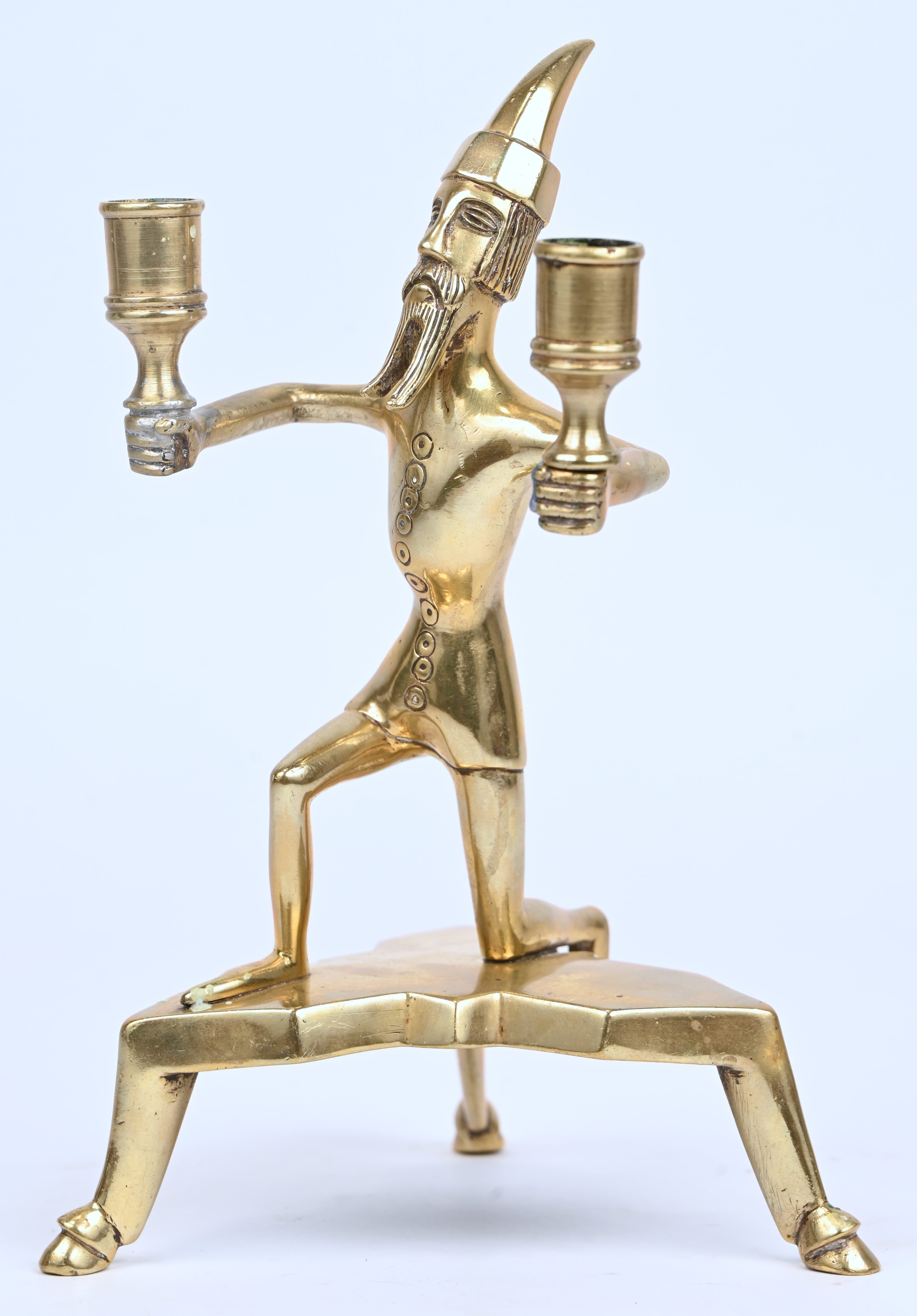 Een bronzen kandelaar in de vorm van een knielende man. Naar antiek voorbeeld Een bronzen kandelaar in de vorm van een knielende man. Naar antiek voorbeeld.