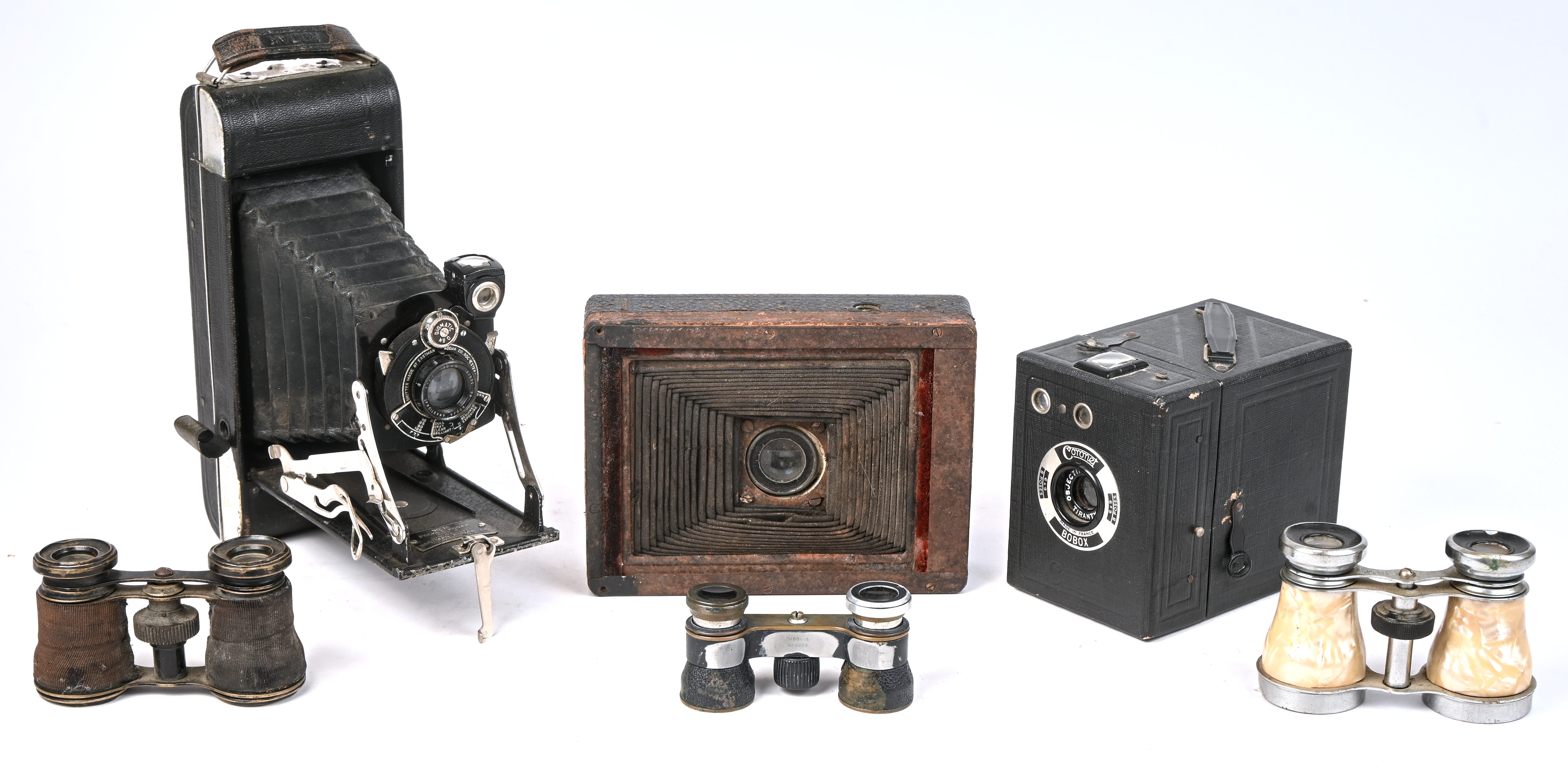 Drie oude theaterkijkers (slijtage), evenals drie oude fototoestellen, Coronet Bobox, één met balg, één Kodak in lederen foedraal (slijtage en letsels) Drie oude theaterkijkers (slijtage), evenals drie oude fototoestellen, Coronet Bobox, één met balg, één Kodak in lederen foedraal (slijtage en letsels).