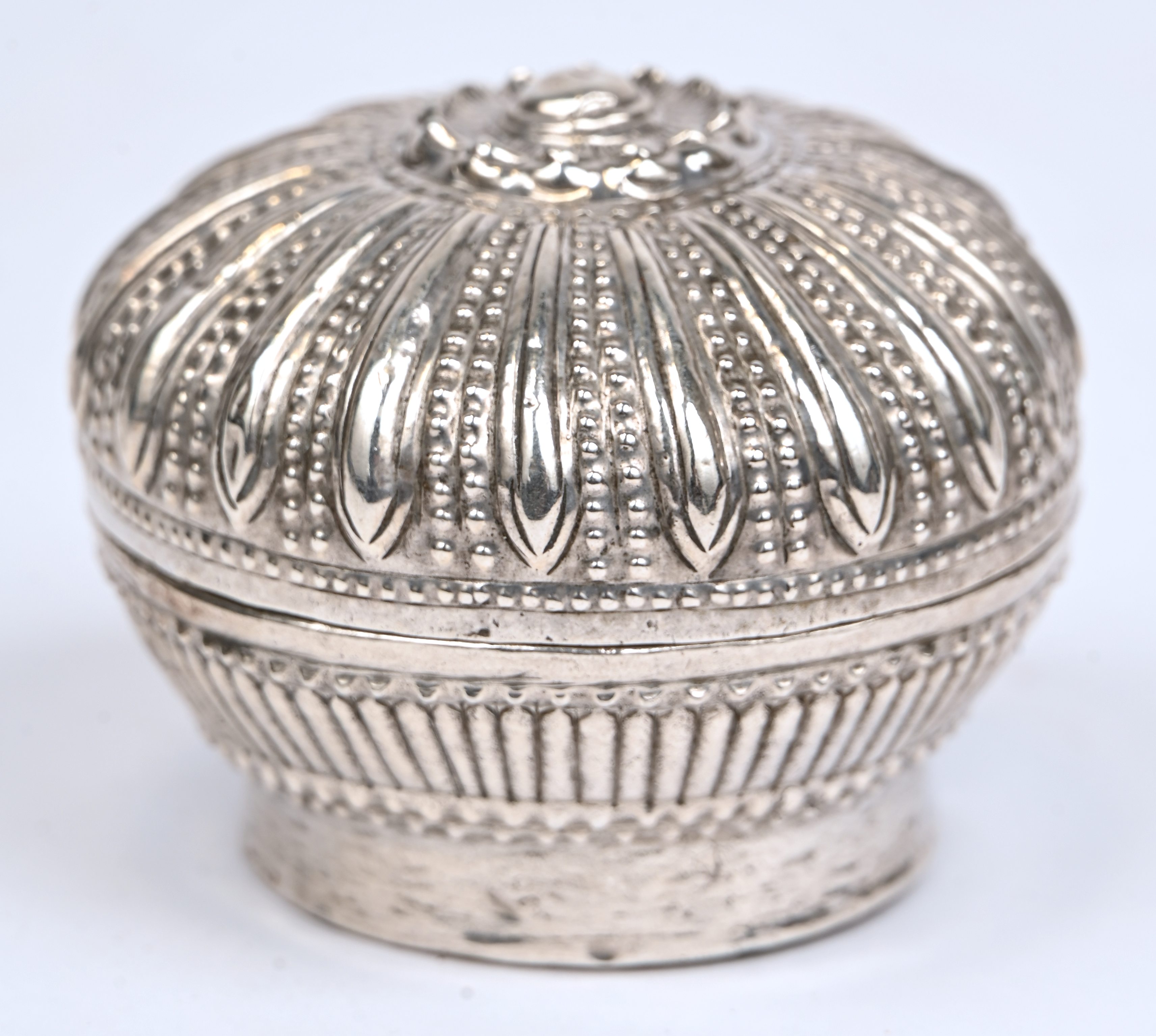 Een rond doosje van gedreven zilver. Indisch werk, zonder merk. AR 4 Een rond doosje van gedreven zilver. Indisch werk, zonder merk. AR 4.