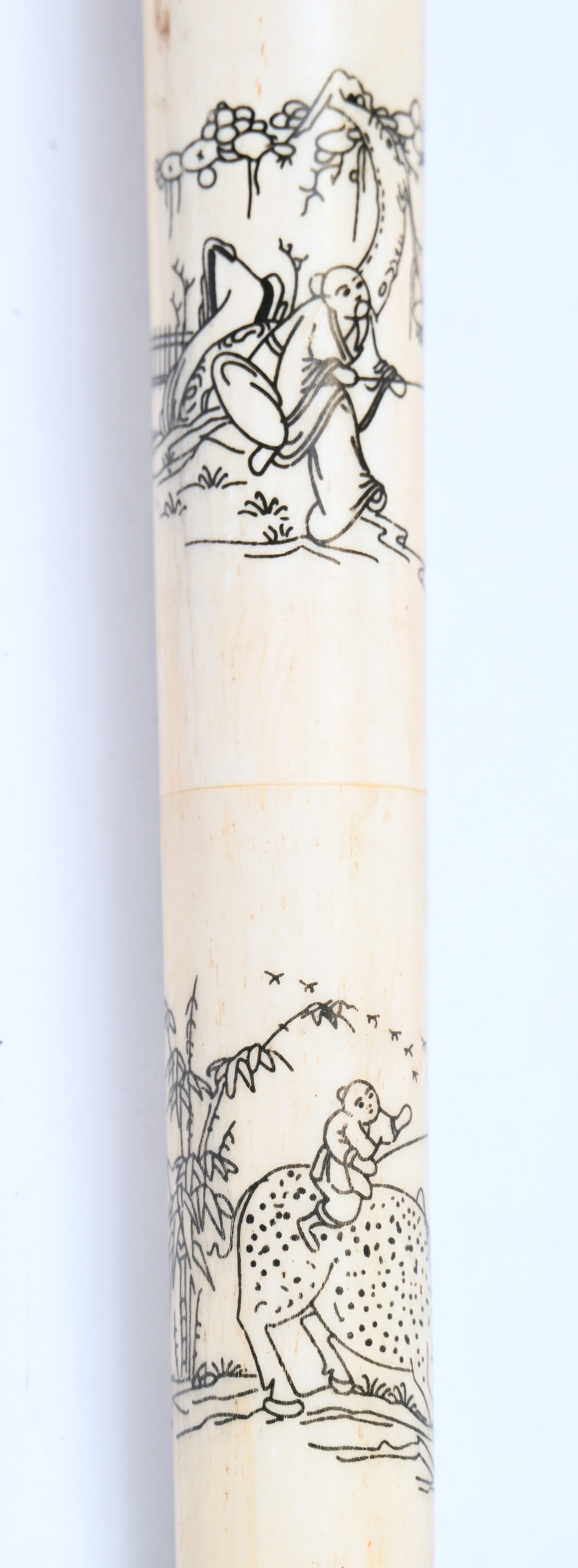 Een wandelstok in hout en been met Oosterse decoraties. Gebarsten net boven het midden Een wandelstok in hout en been met Oosterse decoraties. Gebarsten net boven het midden.