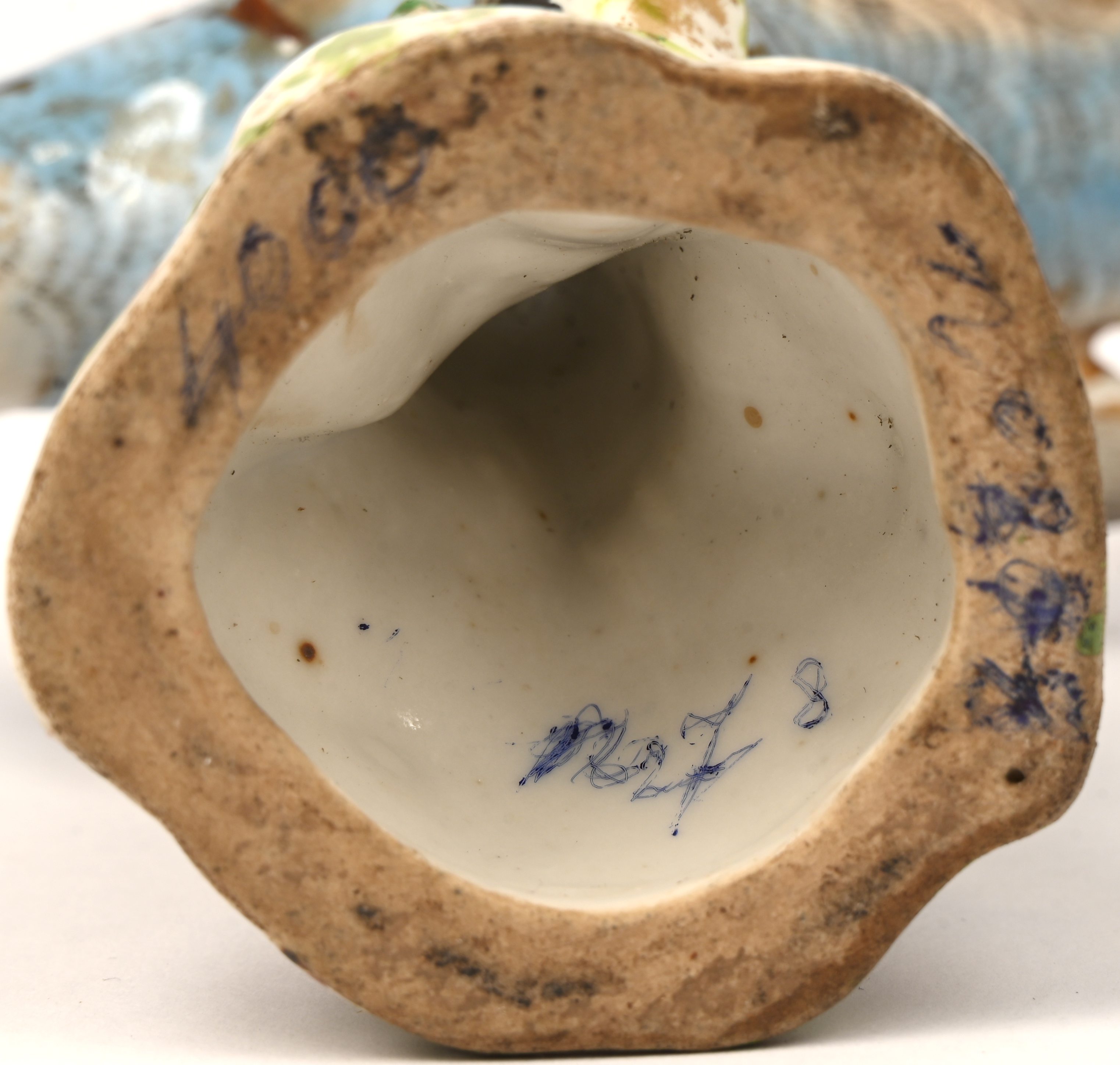 Een porseleinen beeldje van een blauwe parkiet. Gemerkt met gekruiste pijlen. Meermaals gelijmd Een porseleinen beeldje van een blauwe parkiet. Gemerkt met gekruiste pijlen. Meermaals gelijmd.