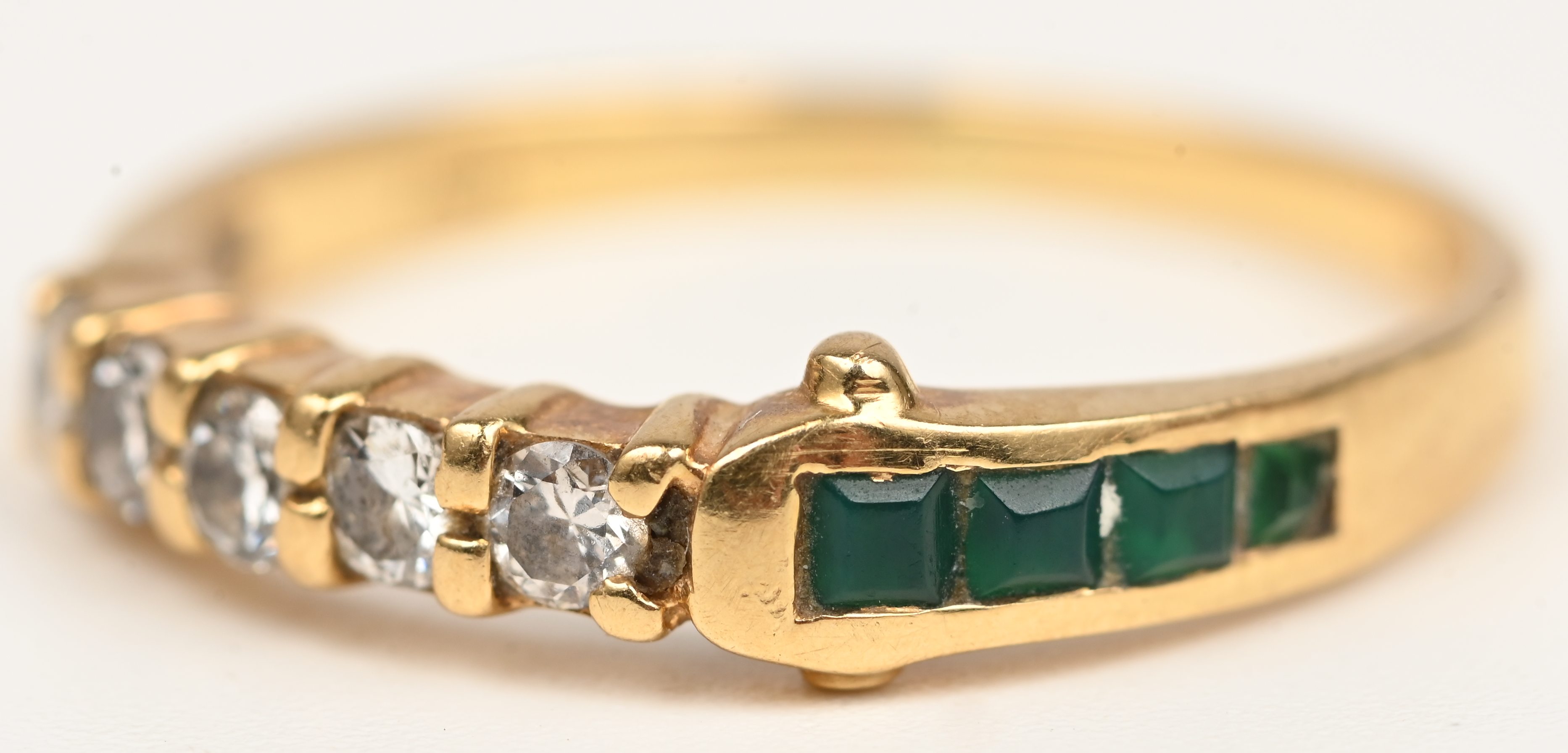 Een 18 kt geelgouden ring bezet met briljantjes en smaragd baguettes met een gezamenlijk gewicht van +- 0,20 ct Een 18 kt geelgouden ring bezet met briljantjes en smaragd baguettes met een gezamenlijk gewicht van +- 0,20 ct.