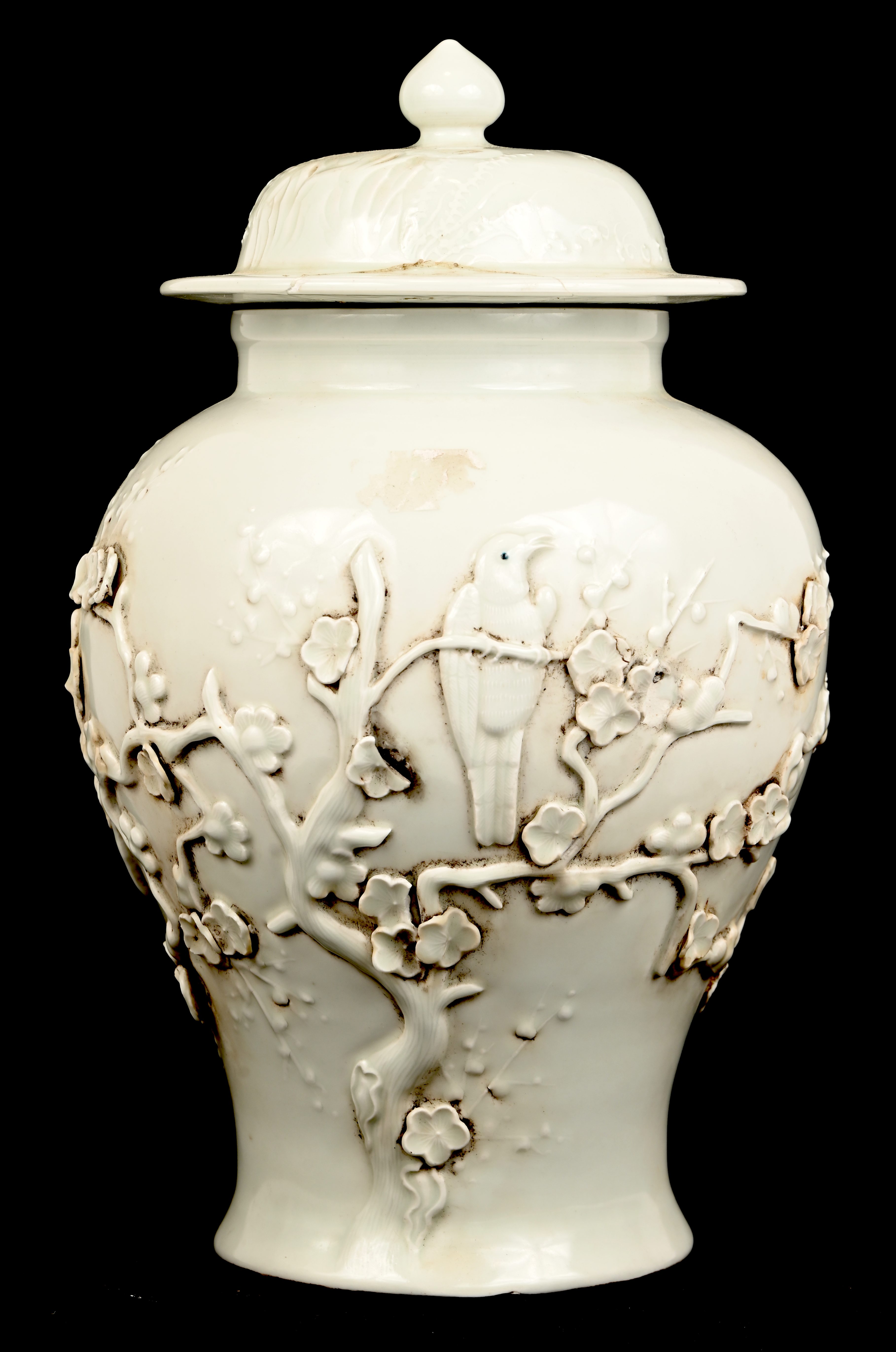 Een Chinese dekselvaas, blanc-de Chine, met een decor van bloesems en vogels. Deksel gelijmd Een Chinese dekselvaas, blanc-de Chine, met een decor van bloesems en vogels. Deksel gelijmd.