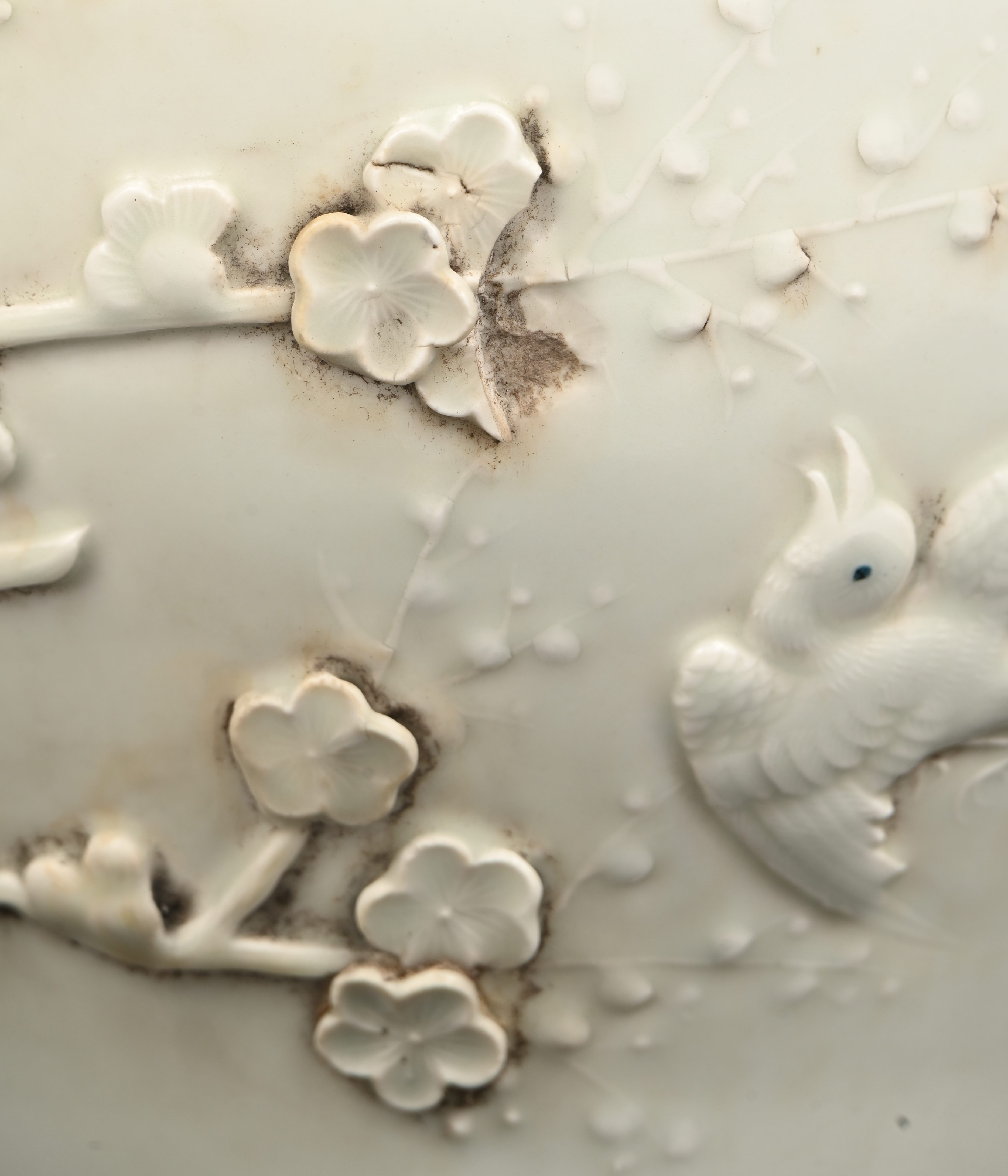 Een Chinese dekselvaas, blanc-de Chine, met een decor van bloesems en vogels. Deksel gelijmd Een Chinese dekselvaas, blanc-de Chine, met een decor van bloesems en vogels. Deksel gelijmd.