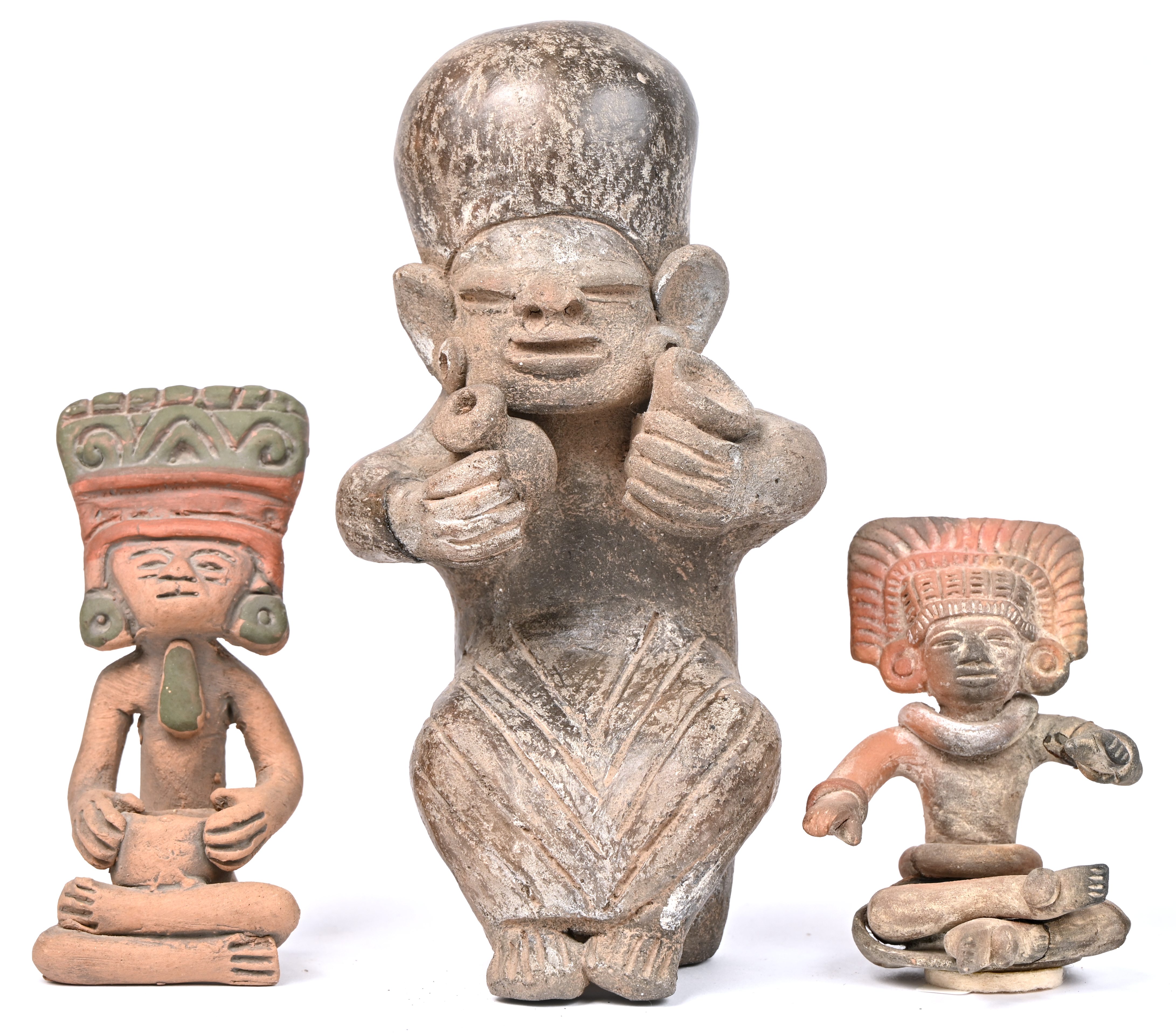 Drie aardewerken beeldjes van gezeten figuren met hoofdtooi en vaatwerk in de hand. In precolumbiaanse stijl Drie aardewerken beeldjes van gezeten figuren met hoofdtooi en vaatwerk in de hand. In precolumbiaanse stijl.