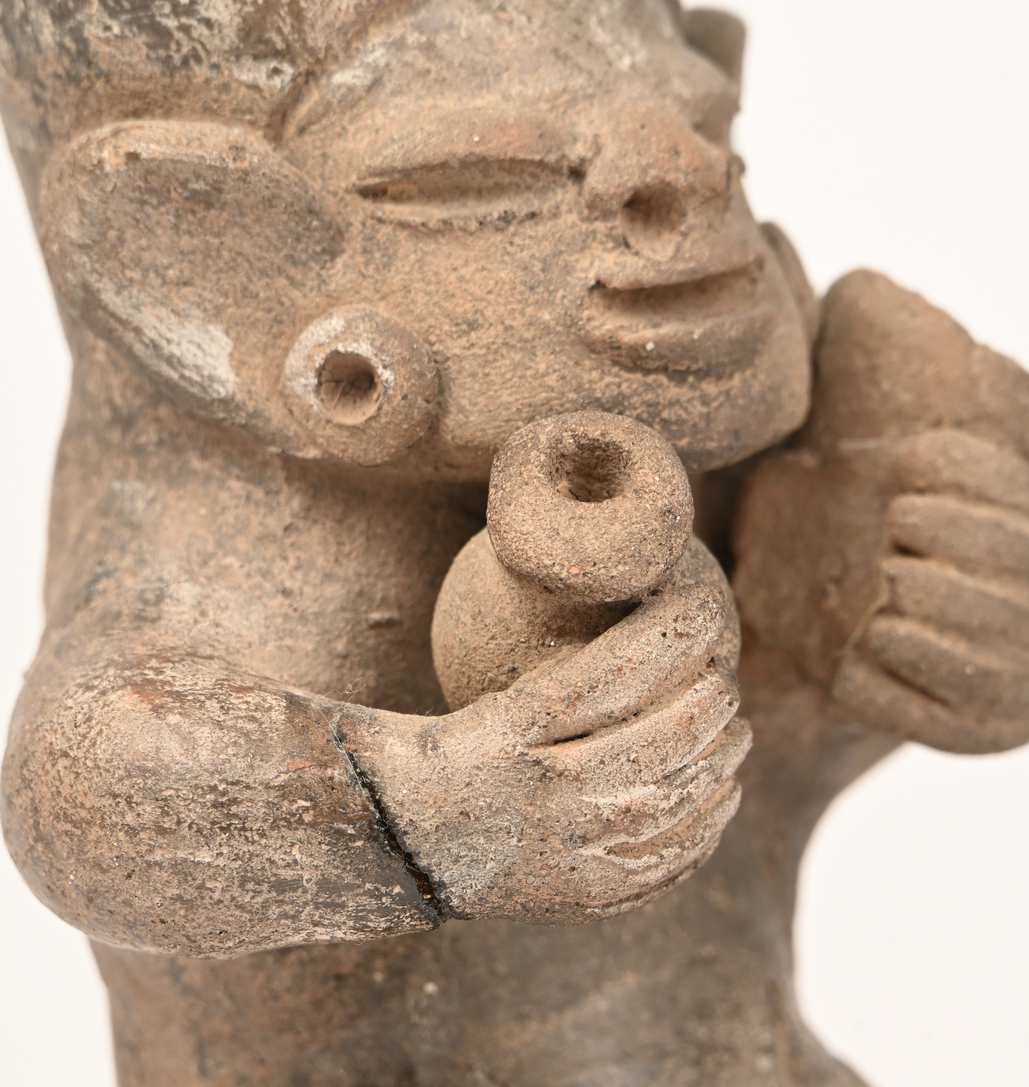 Drie aardewerken beeldjes van gezeten figuren met hoofdtooi en vaatwerk in de hand. In precolumbiaanse stijl Drie aardewerken beeldjes van gezeten figuren met hoofdtooi en vaatwerk in de hand. In precolumbiaanse stijl.