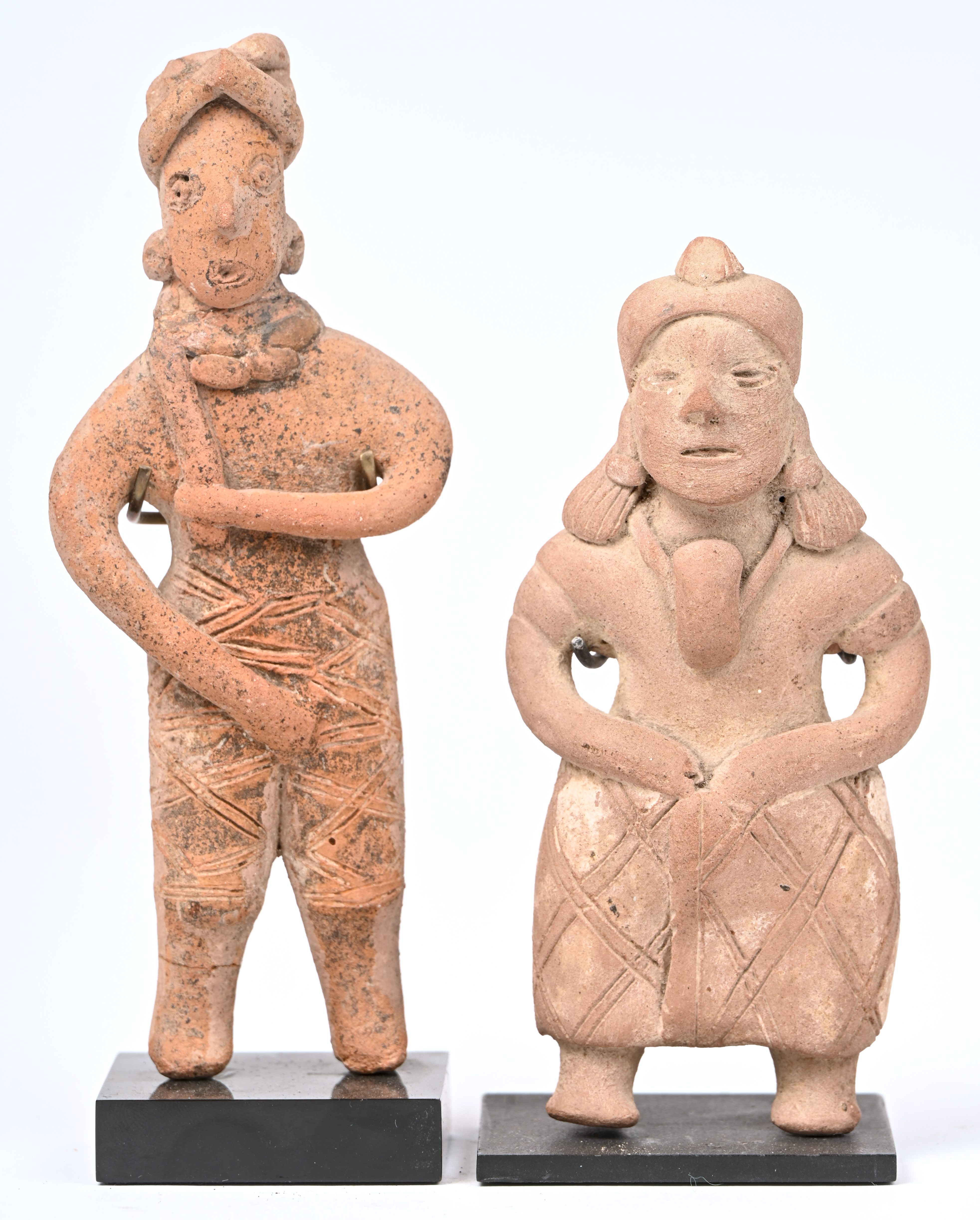 Twee aardewerken beeldjes van staande figuren met hoofdtooi. In precolumbiaanse stijl Twee aardewerken beeldjes van staande figuren met hoofdtooi. In precolumbiaanse stijl.
