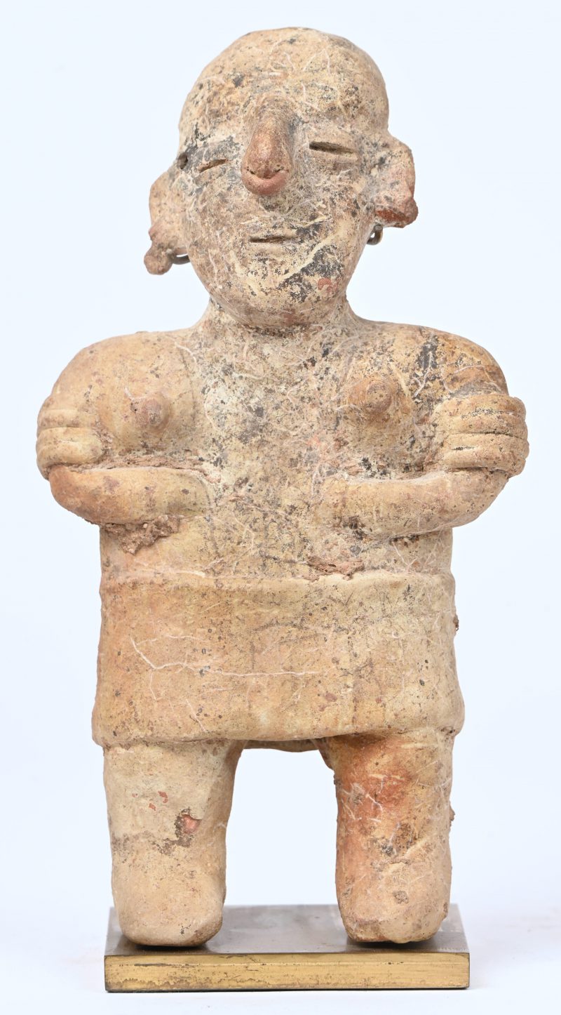 Een aardewerken beeldje van een staand vrouwelijk figuur met armbanden