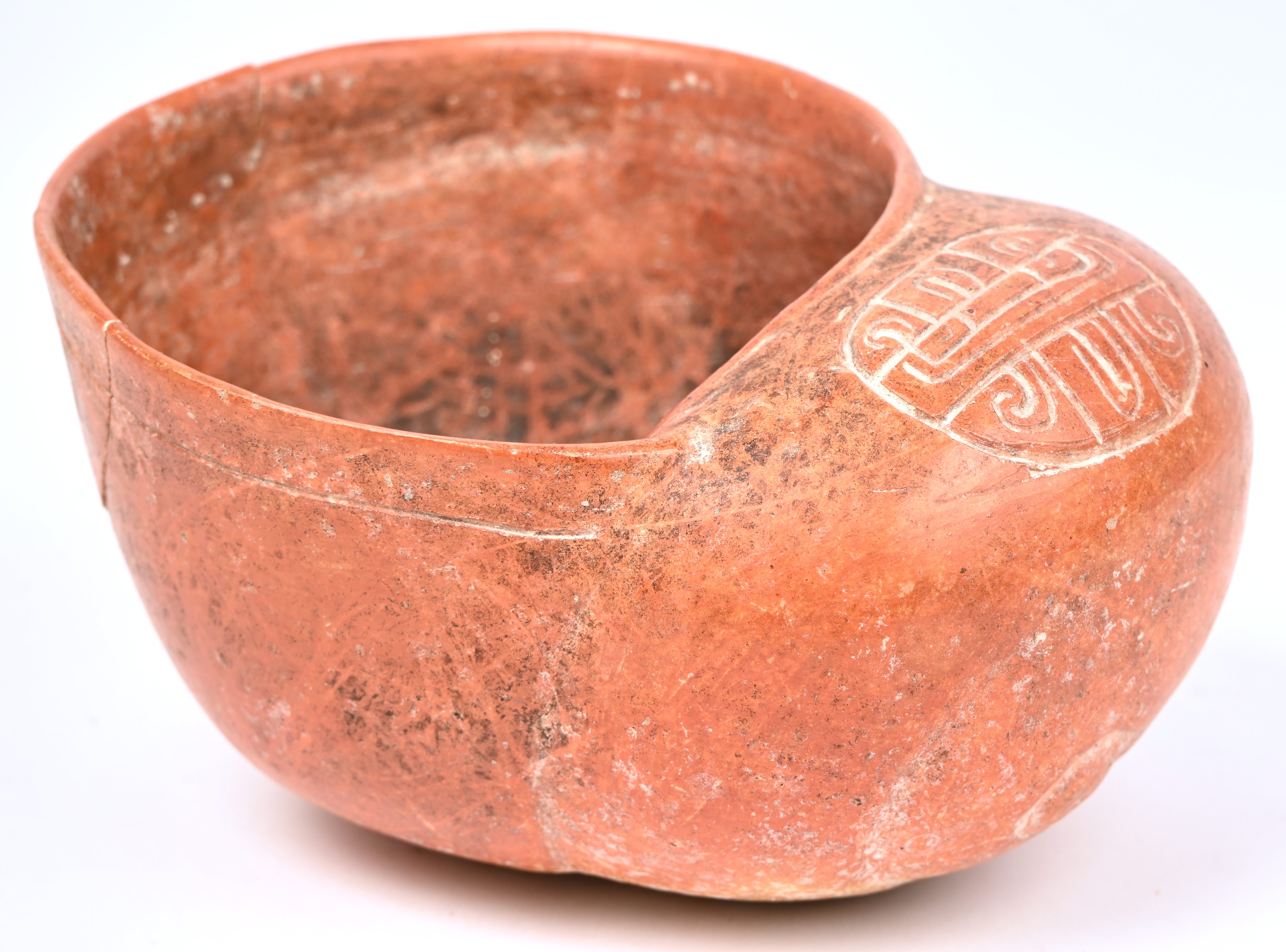 Een vaas in de vorm van een slakschelp. Rood aardewerk met tekening in relief, in precolumbiaanse Maya-stijl. Met herstelling aan de rand Een vaas in de vorm van een slakschelp. Rood aardewerk met tekening in relief, in precolumbiaanse Maya-stijl. Met herstelling aan de rand.