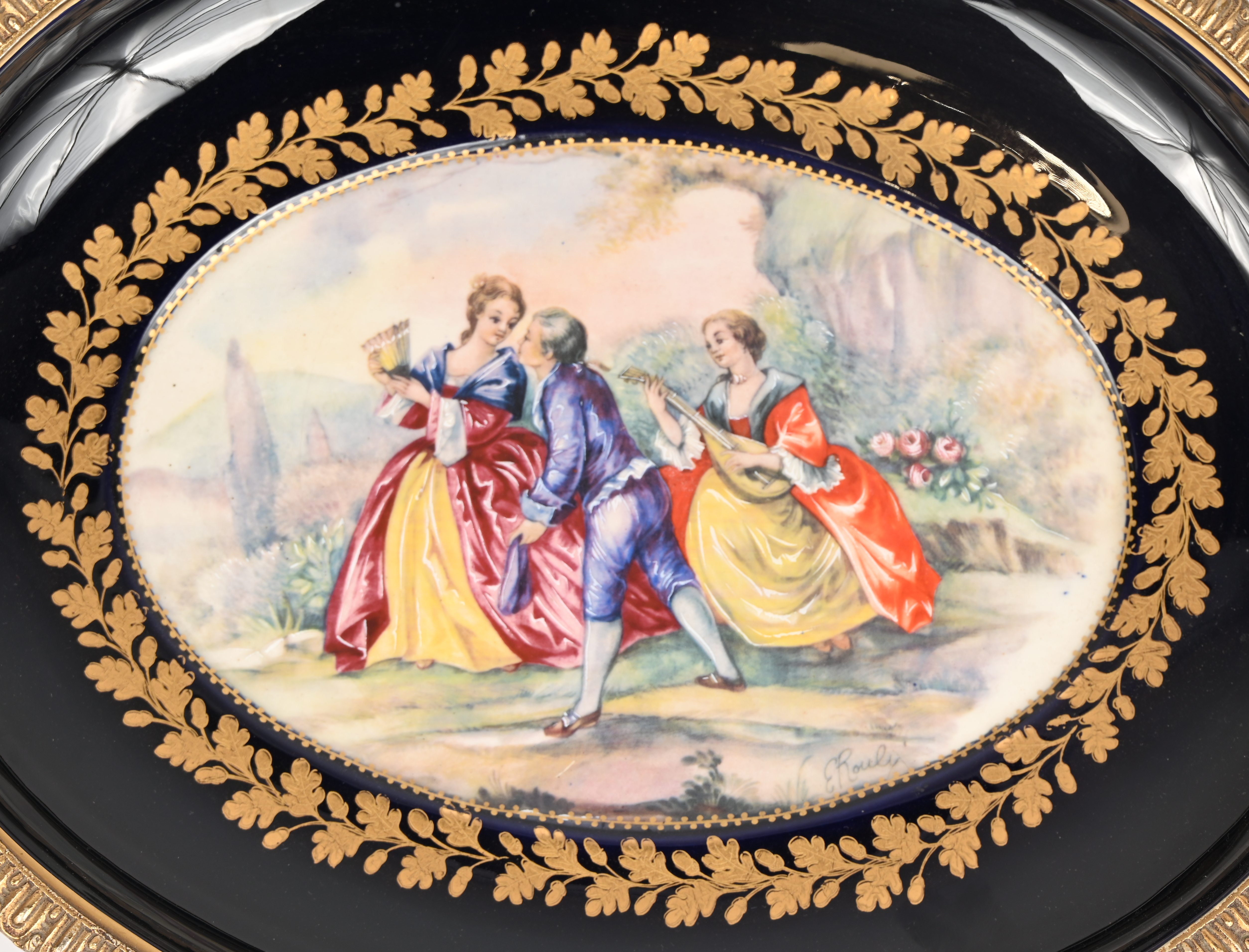 Een porseleinen schaal met messing handvatten en onderstel, onderaan opschrift’A.C.F. Décor bleu Sèvres - fait à la main Een porseleinen schaal met messing handvatten en onderstel, onderaan opschrift’A.C.F. Décor bleu Sèvres - fait à la main.