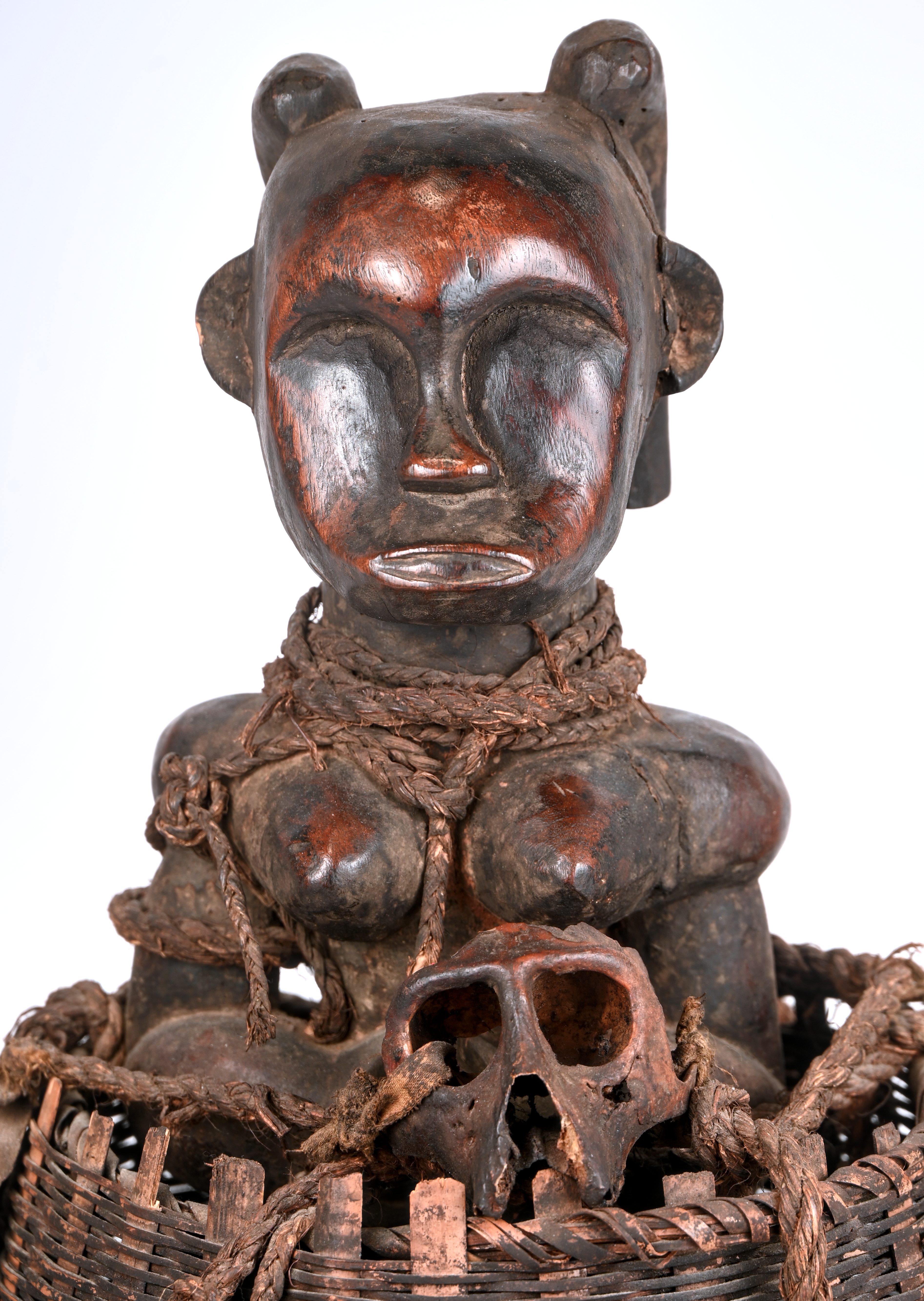 Een Afrikaans fetisjbeeld in een gevlochten mand, gedecoreerd met schelpen en apenschedels Een Afrikaans fetisjbeeld in een gevlochten mand, gedecoreerd met schelpen en apenschedels.