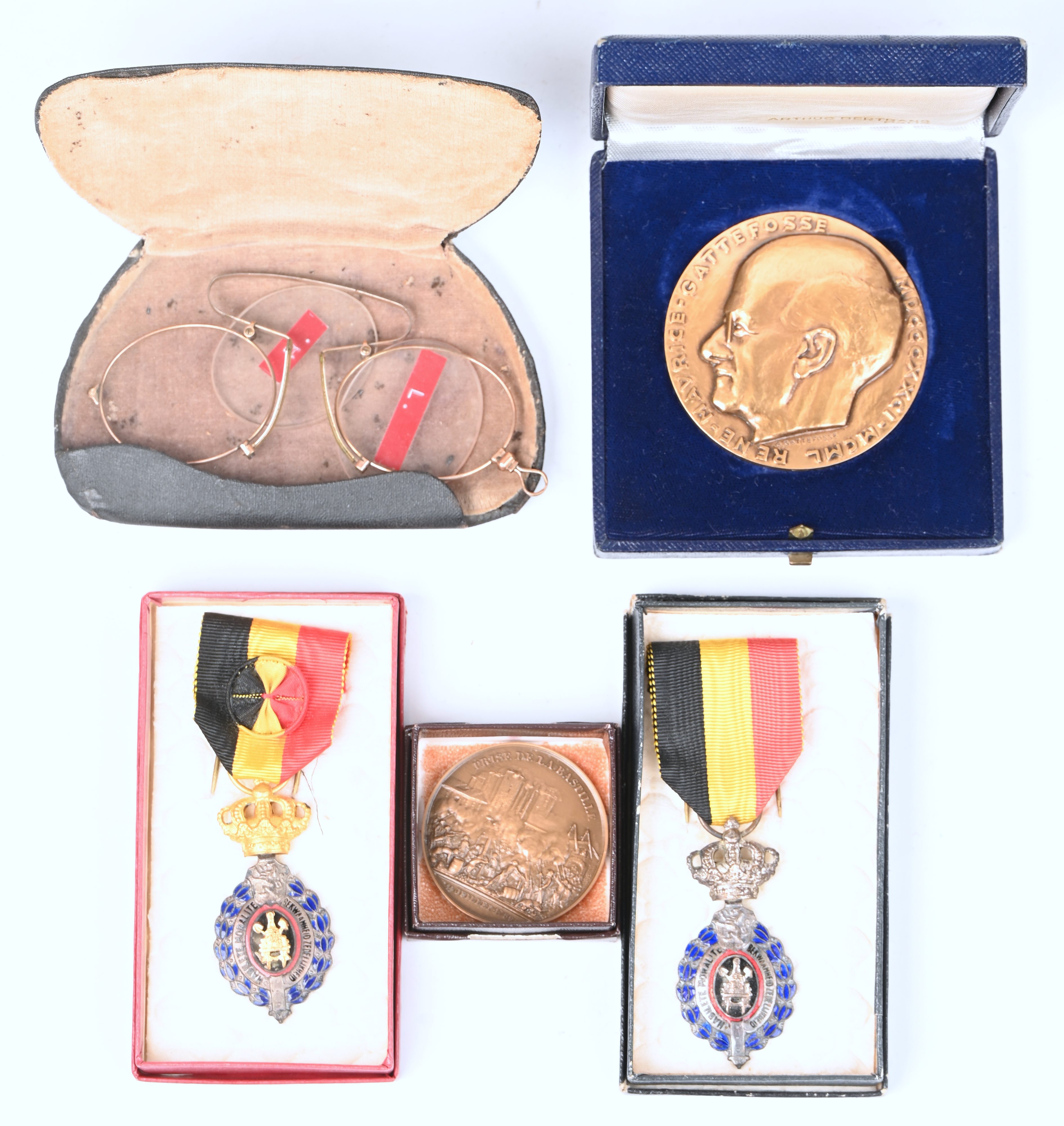 Een gevarieerd lot bestaande uit 2 bronzen penningen, 2 eretekens voor arbeid en een antieke pince-nez in etui Een gevarieerd lot bestaande uit 2 bronzen penningen, 2 eretekens voor arbeid en een antieke pince-nez in etui.