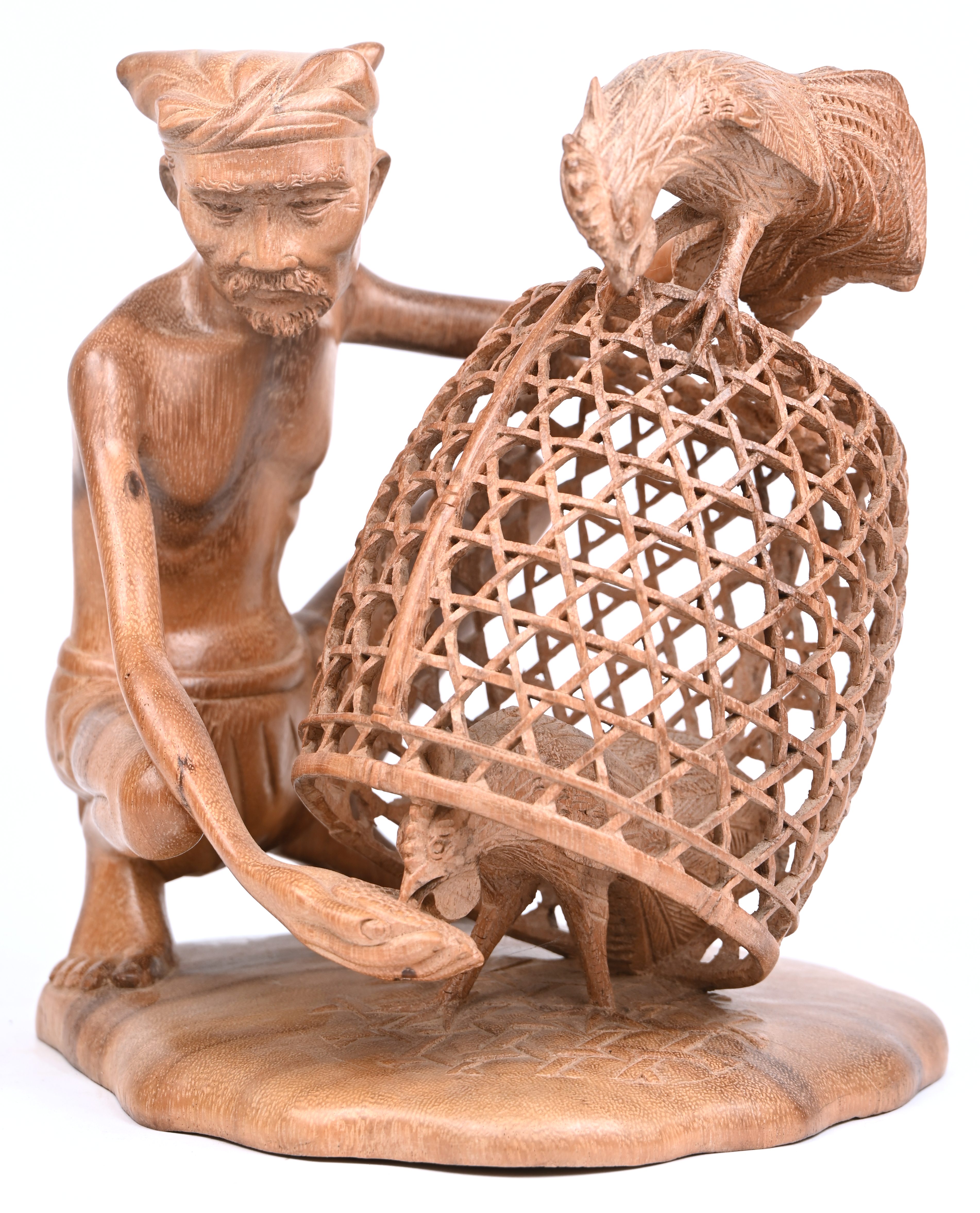 Een gesculpteerd houten beeldje van een man met hanen, Indonesisch werk Een gesculpteerd houten beeldje van een man met hanen, Indonesisch werk.