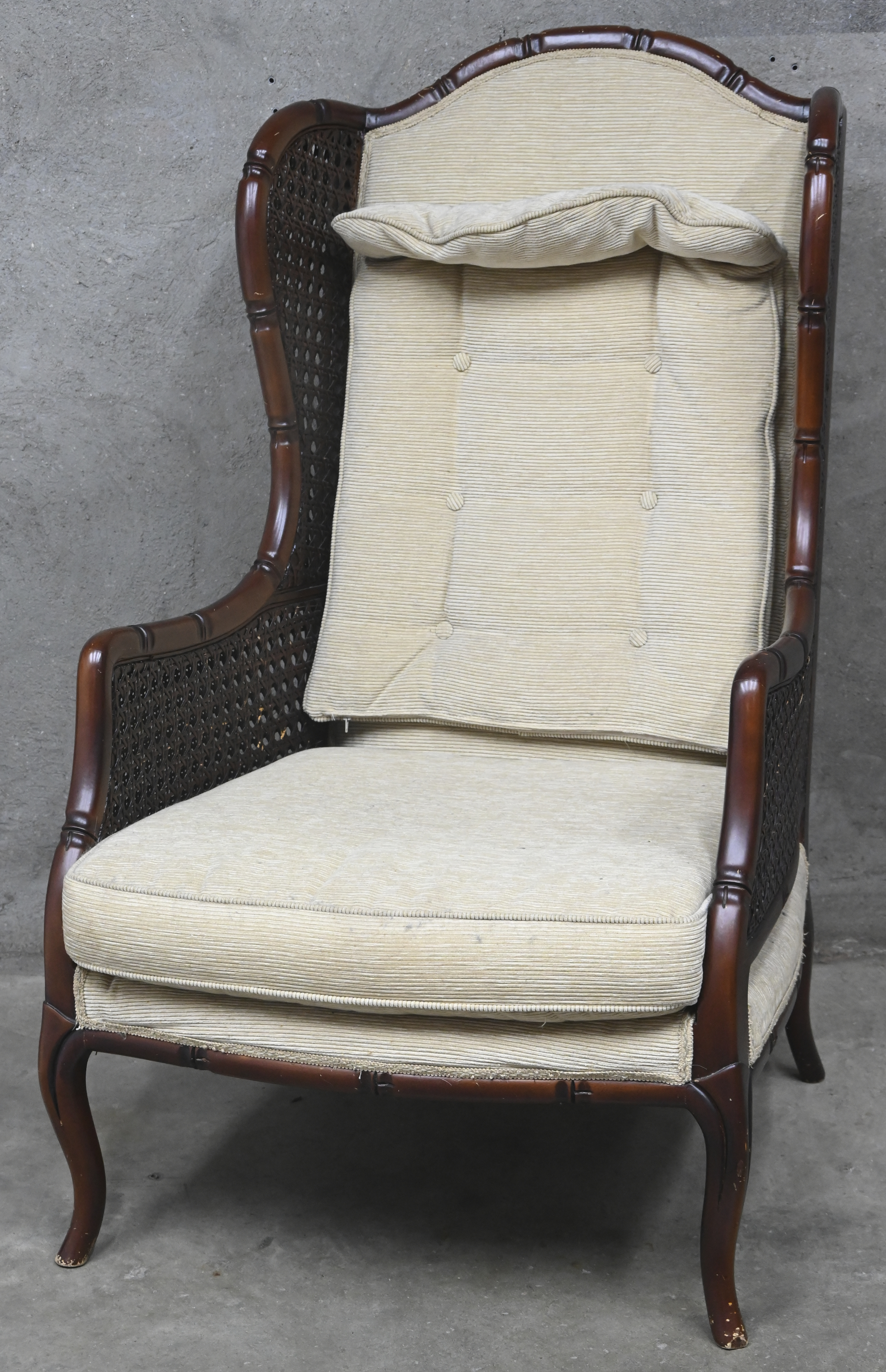 Een armstoel, faux-bamboe en vlechtwerk, beige velours bekleding Een armstoel, faux-bamboe en vlechtwerk, beige velours bekleding.