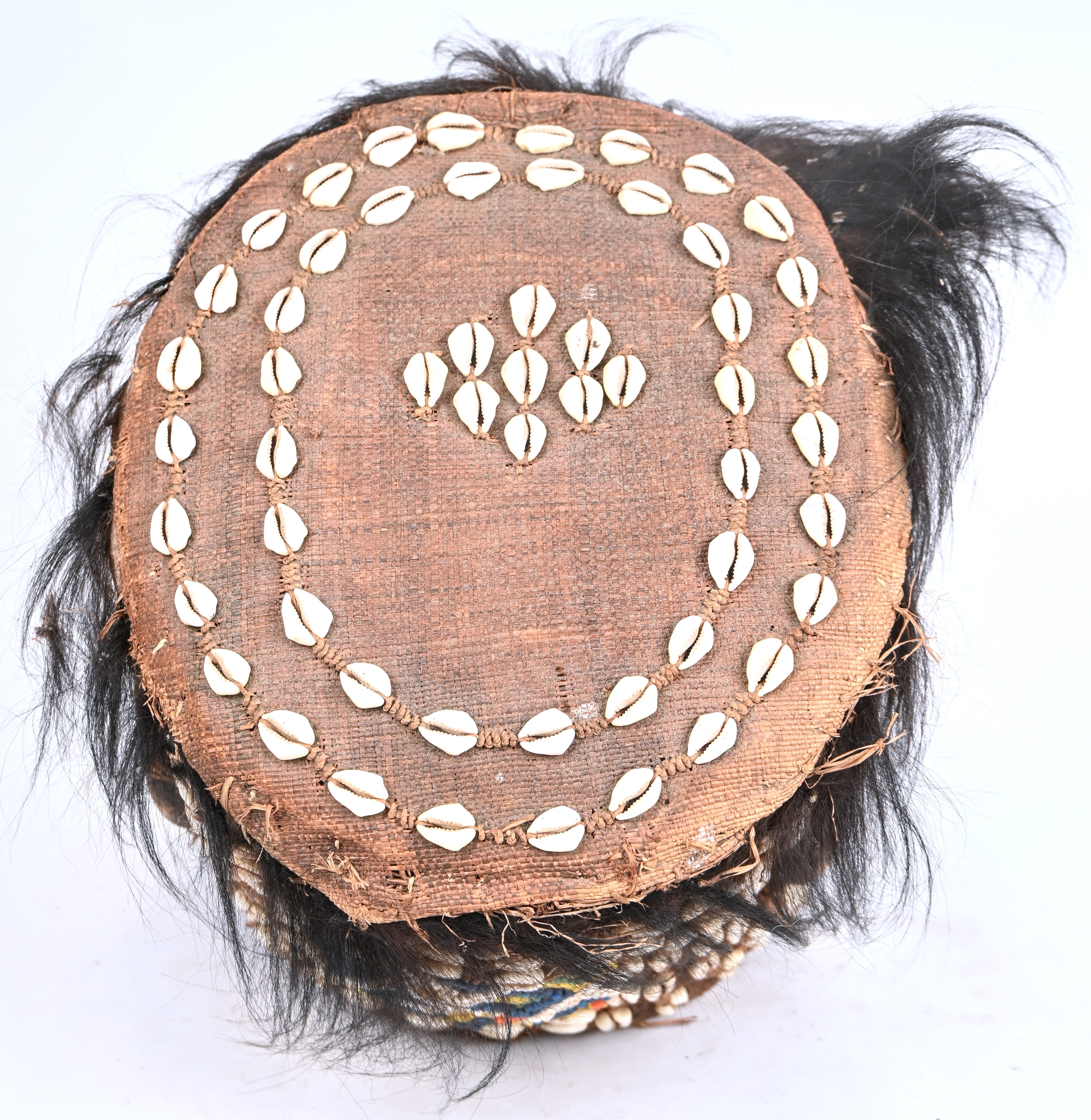 Een Afrikaans Kuba helmmasker bekleed met kralen, schelpjes en haar Een Afrikaans Kuba helmmasker bekleed met kralen, schelpjes en haar.