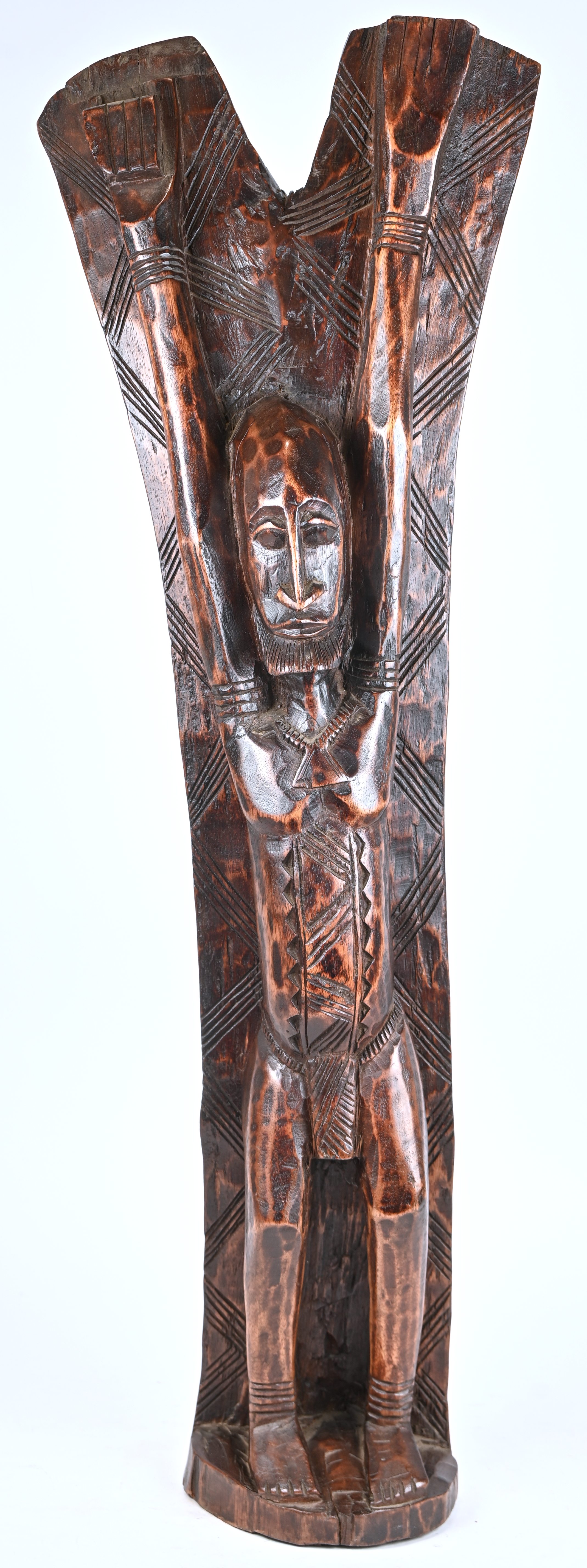 Een Afrikaans beeld van een man met gestrekte armen, van donker gepatineerd hout. Met op de rug een krokodil en twee slangen in bas relief Een Afrikaans beeld van een man met gestrekte armen, van donker gepatineerd hout. Met op de rug een krokodil en twee slangen in bas relief.