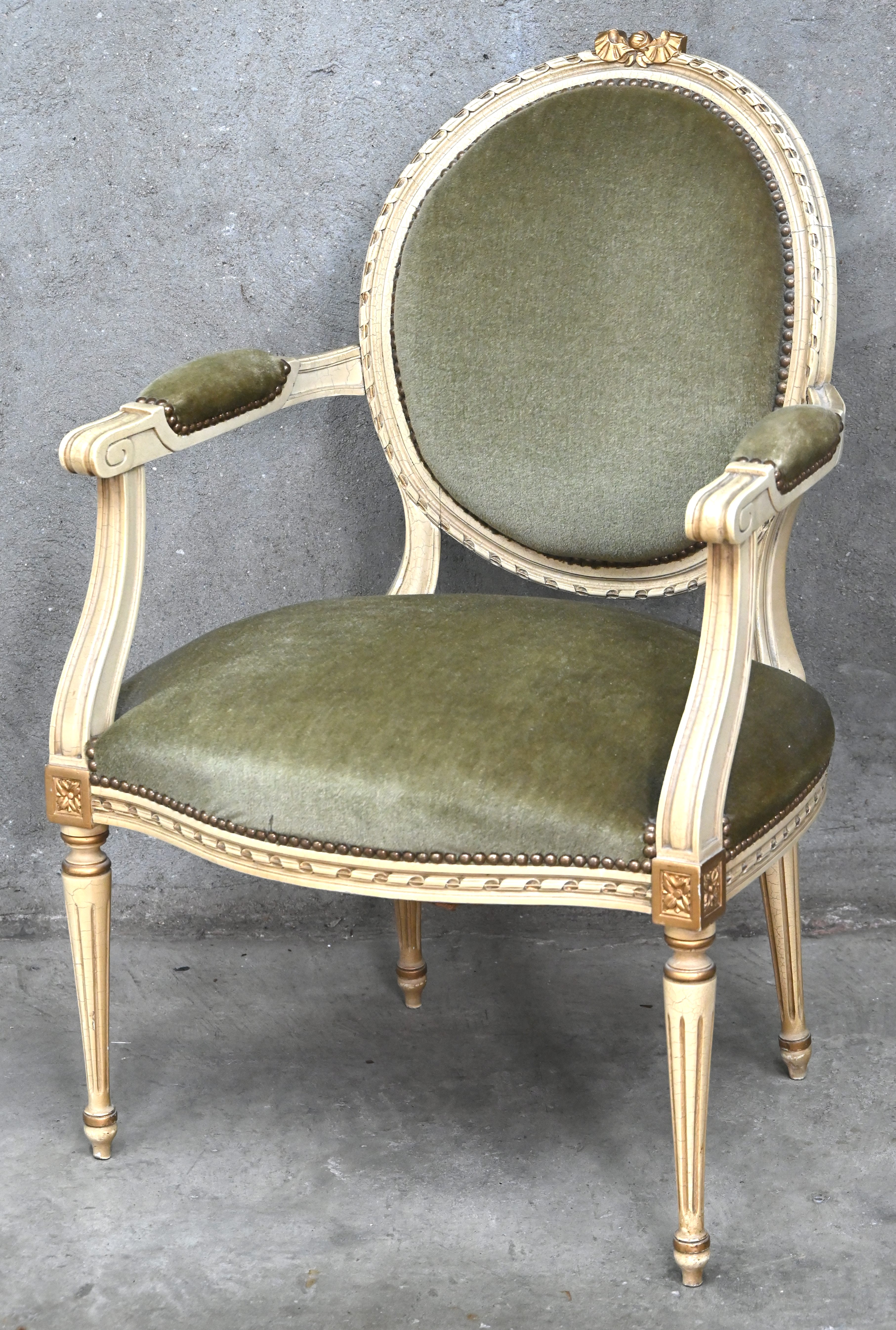 Een armstoel in Louis XVI stijl, gepolychromeerd hout en velours Een armstoel in Louis XVI stijl, gepolychromeerd hout en velours.