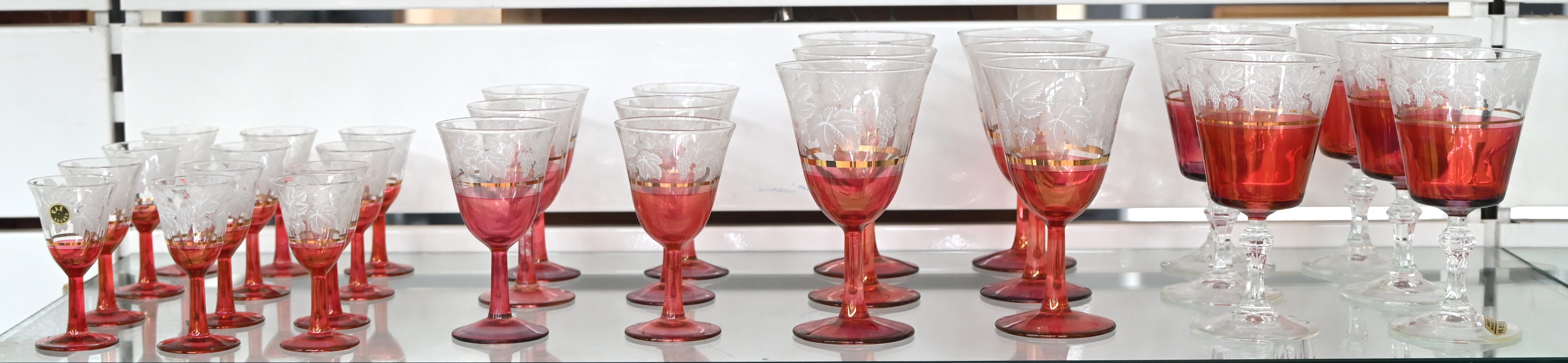 Een tweekleurig krisallen glasservies, roze wit en wit roze met bloemenmotief en vergulde randen. 30 stuks Een tweekleurig krisallen glasservies, roze wit en wit roze met bloemenmotief en vergulde randen. 30 stuks.