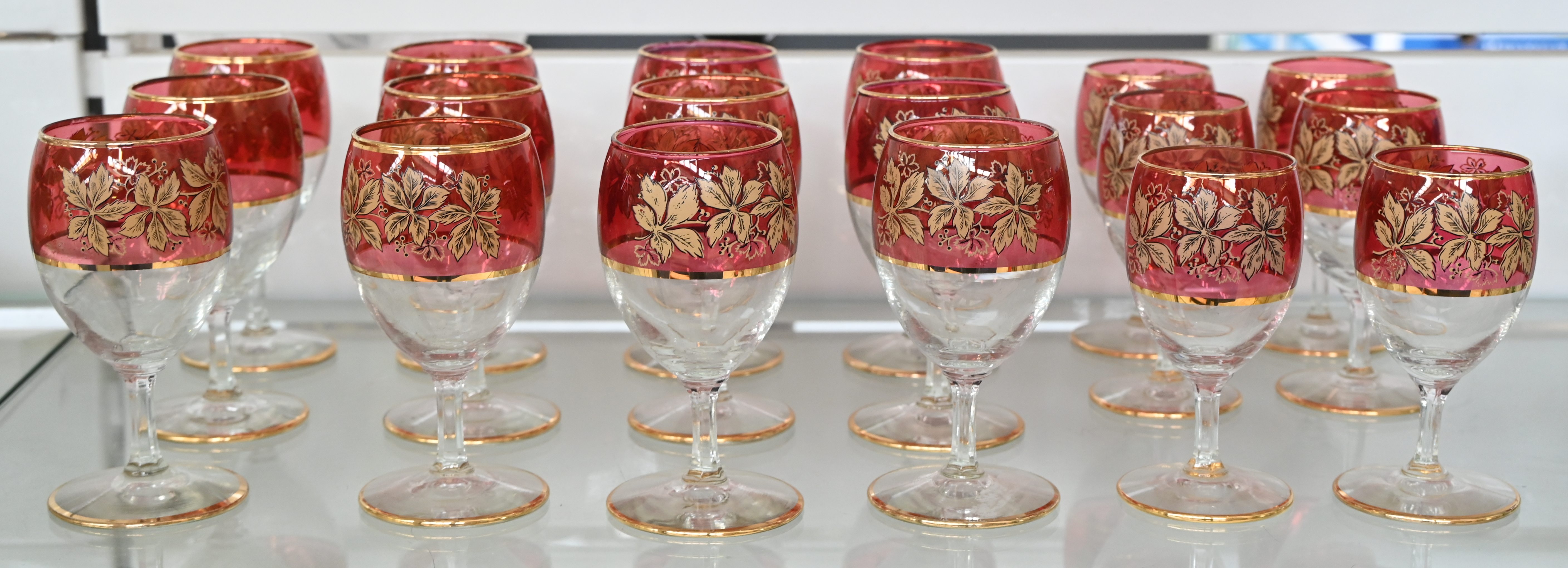Een wit, roze gekleurd kristallen glasservies met verguld bloemenmotief en randen. 18 stuks Een wit, roze gekleurd kristallen glasservies met verguld bloemenmotief en randen. 18 stuks.