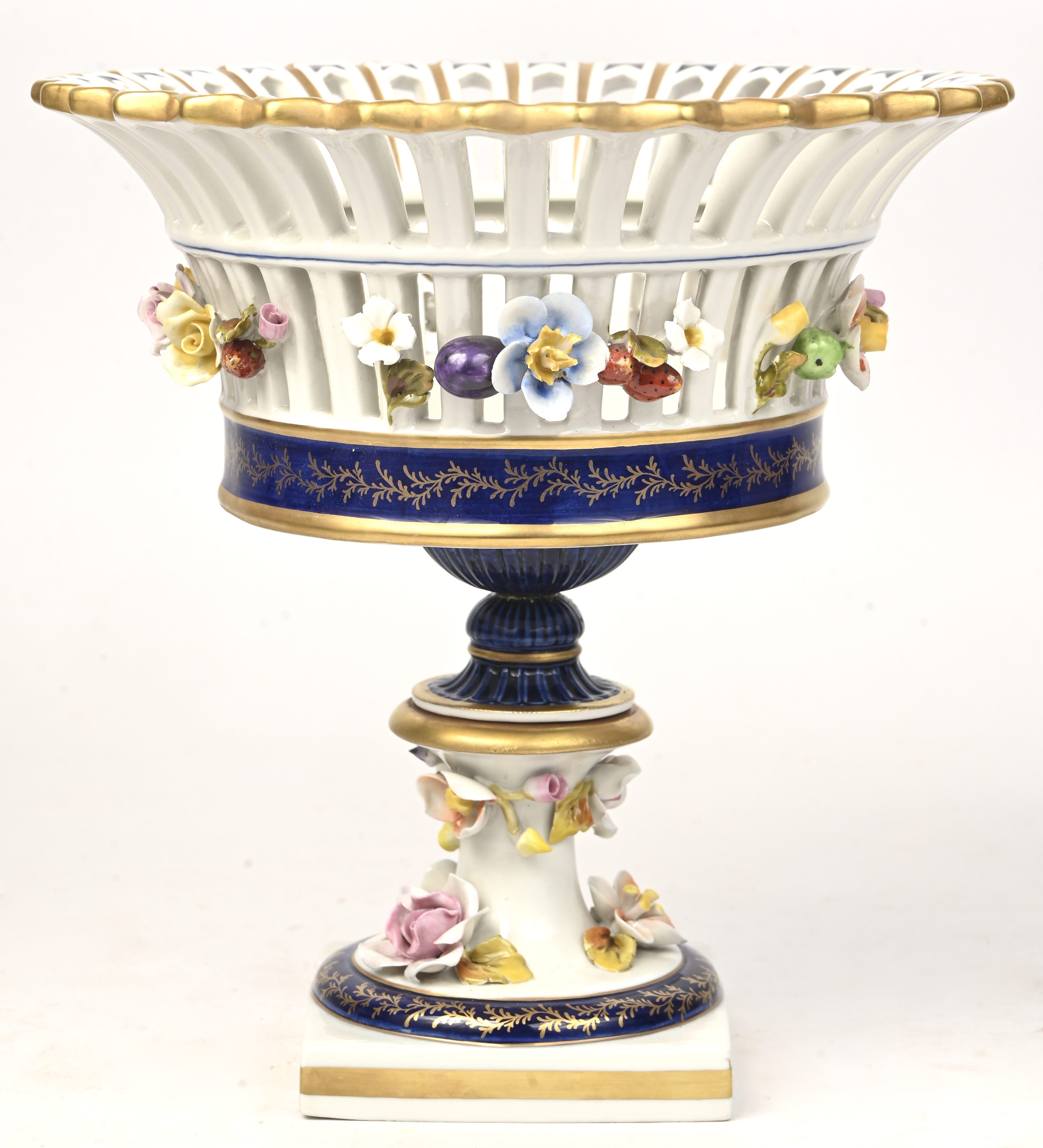 Een opengewerkte porseleinen coupe op voet met bloemen afgewerkt. Made in Italy Een opengewerkte porseleinen coupe op voet met bloemen afgewerkt. Made in Italy.