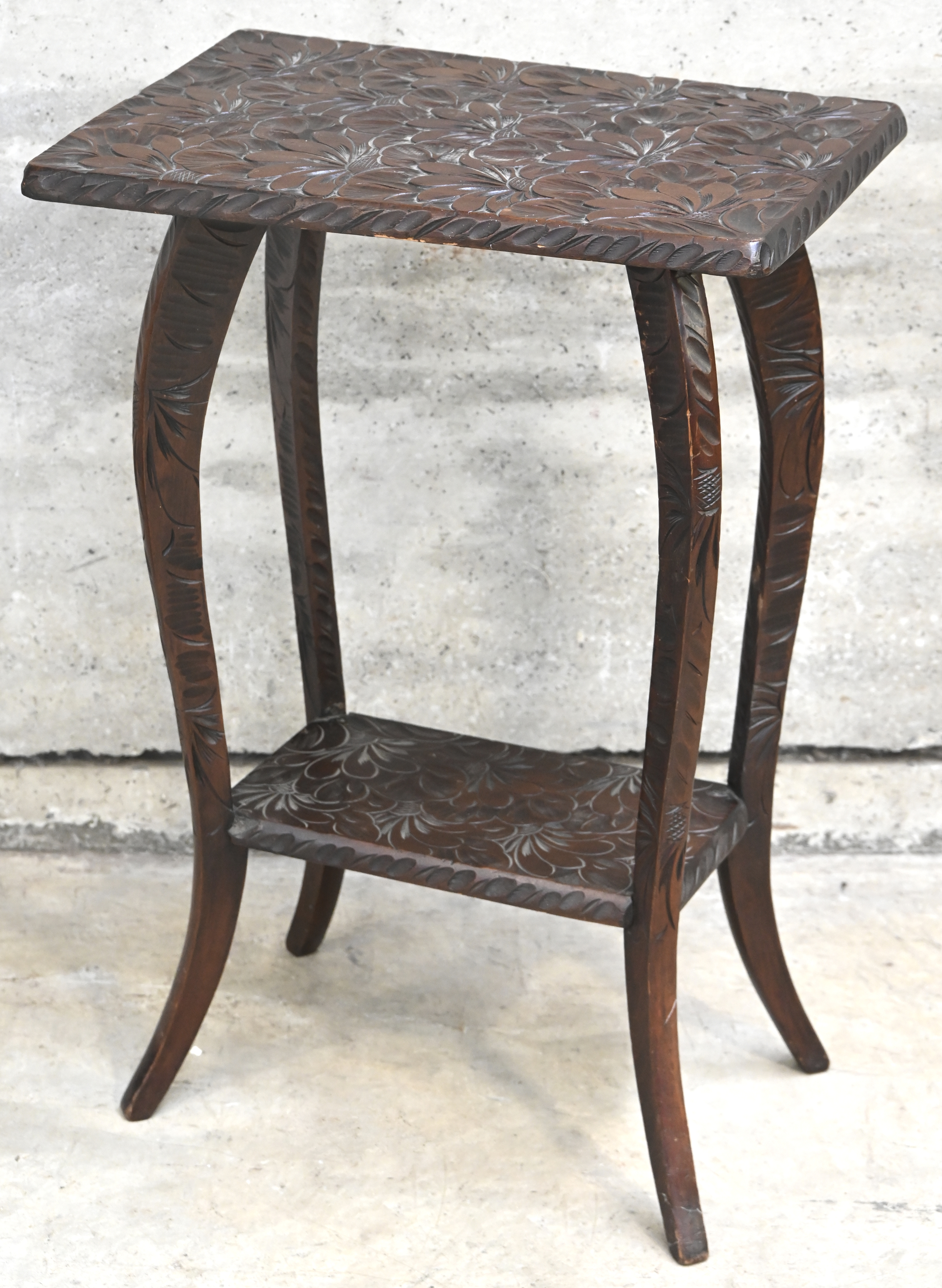 Een gesculpteerd bijzettafeltje, draagt herkomst plaatje: R. Glasstone & Co, Elisabethville & Likasi Een gesculpteerd bijzettafeltje, draagt herkomst plaatje: R. Glasstone & Co, Elisabethville & Likasi.