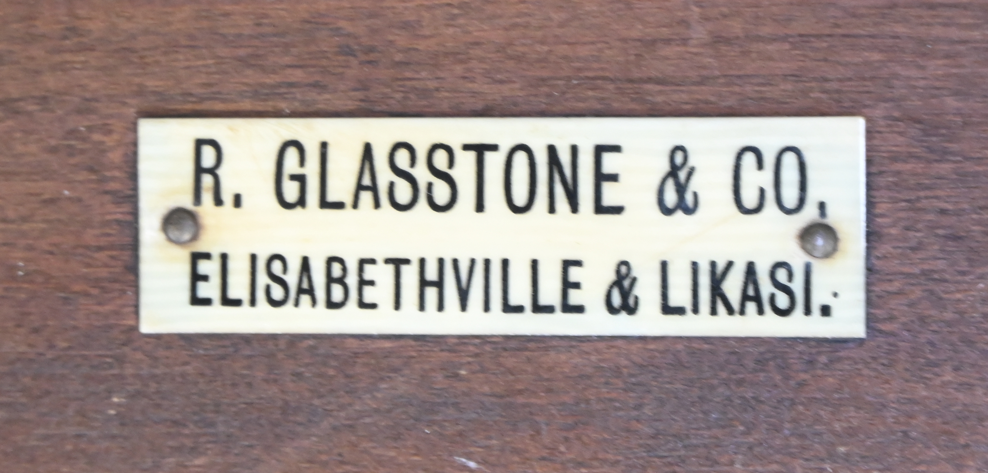 Een gesculpteerd bijzettafeltje, draagt herkomst plaatje: R. Glasstone & Co, Elisabethville & Likasi Een gesculpteerd bijzettafeltje, draagt herkomst plaatje: R. Glasstone & Co, Elisabethville & Likasi.