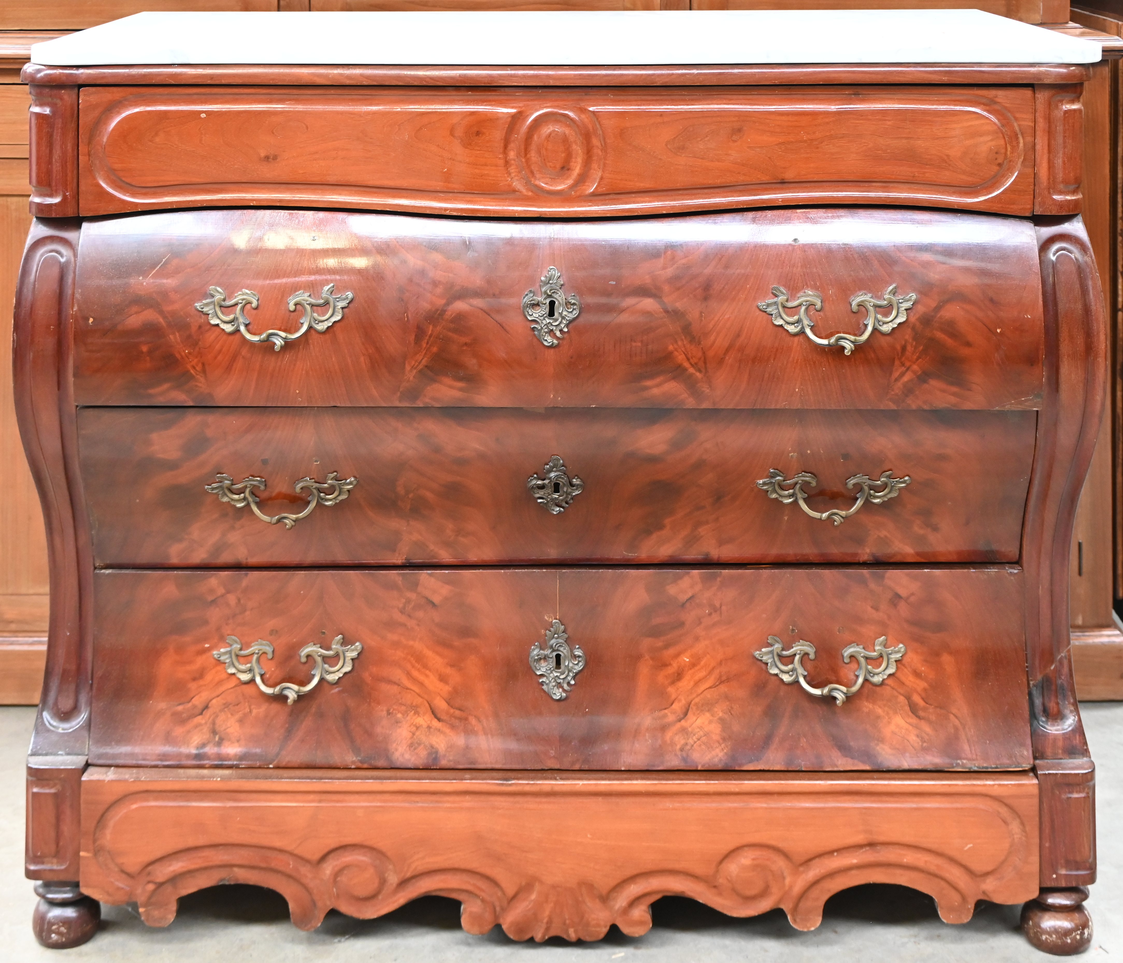 Een Biedermeyer buikcommode met witmarmeren blad. Vijf laden waarvan twee ‘verborgen’, één onder het blad en één in de plint Een Biedermeyer buikcommode met witmarmeren blad. Vijf laden waarvan twee ‘verborgen’, één onder het blad en één in de plint.